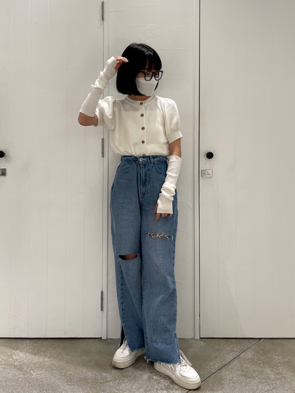 ブルー系のデニムパンツ、ホワイト系のニット/セーター、ホワイト系のその他シューズを着用したレディースの春コーディネートの2枚目の写真