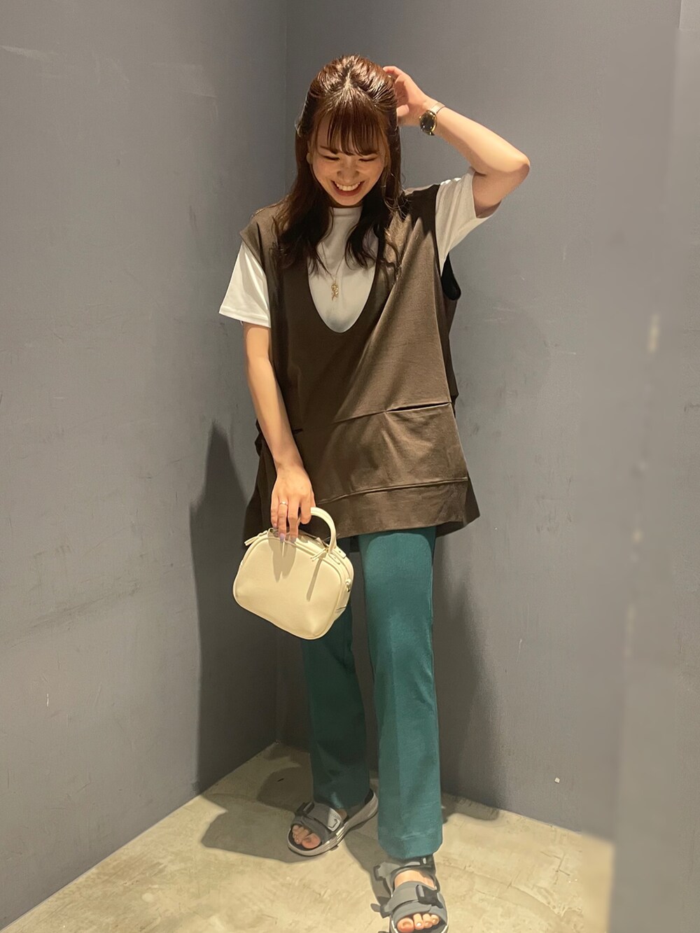 ホワイト系のボストンバッグ、ホワイト系のTシャツ/カットソー、ブラウン系のベストを着用したレディースの夏コーディネートの2枚目の写真