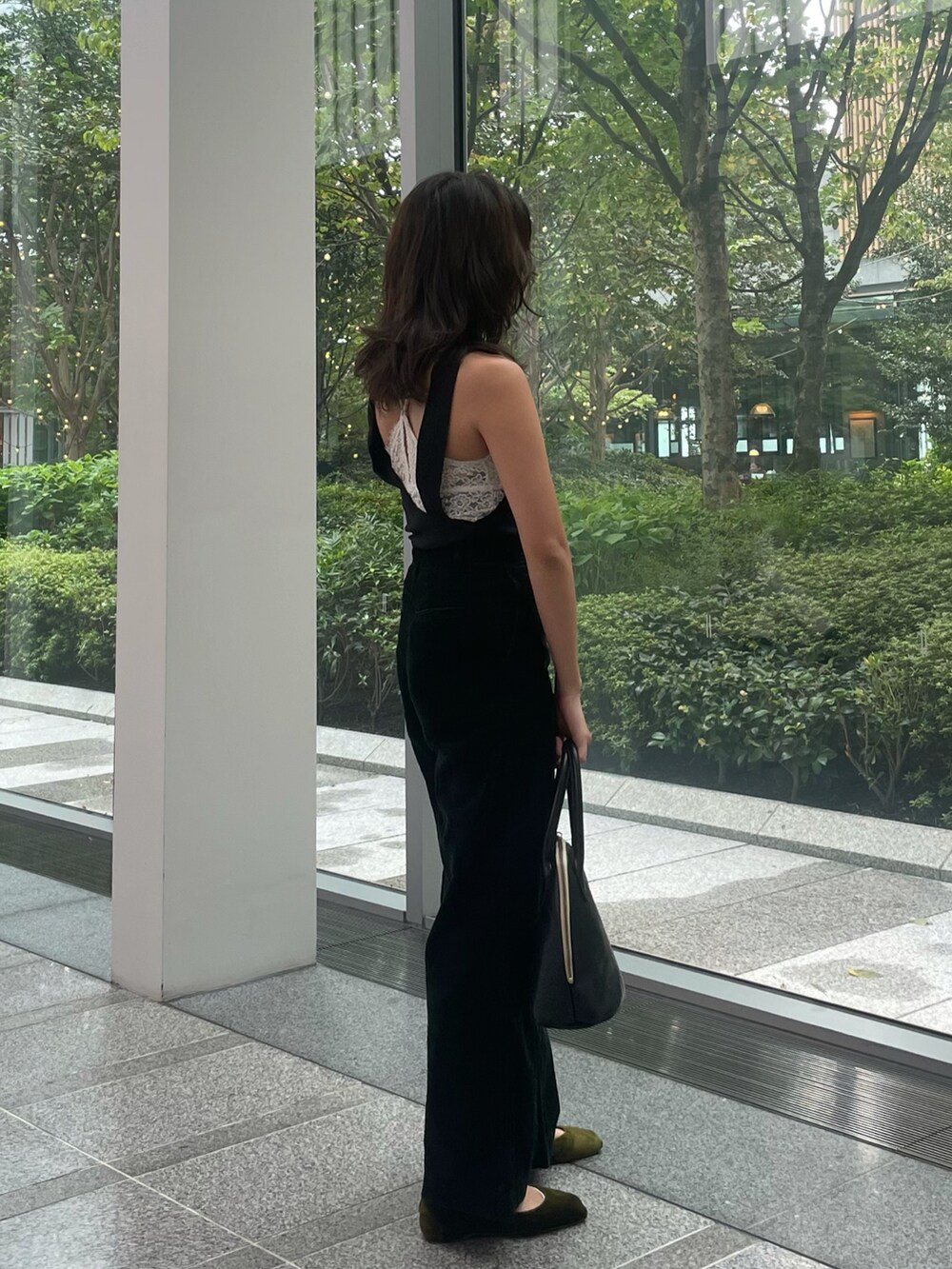 ブラック系のトップス、グリーン系のその他パンツ、ブラック系のハンドバッグを着用したレディースの秋コーディネートの3枚目の写真