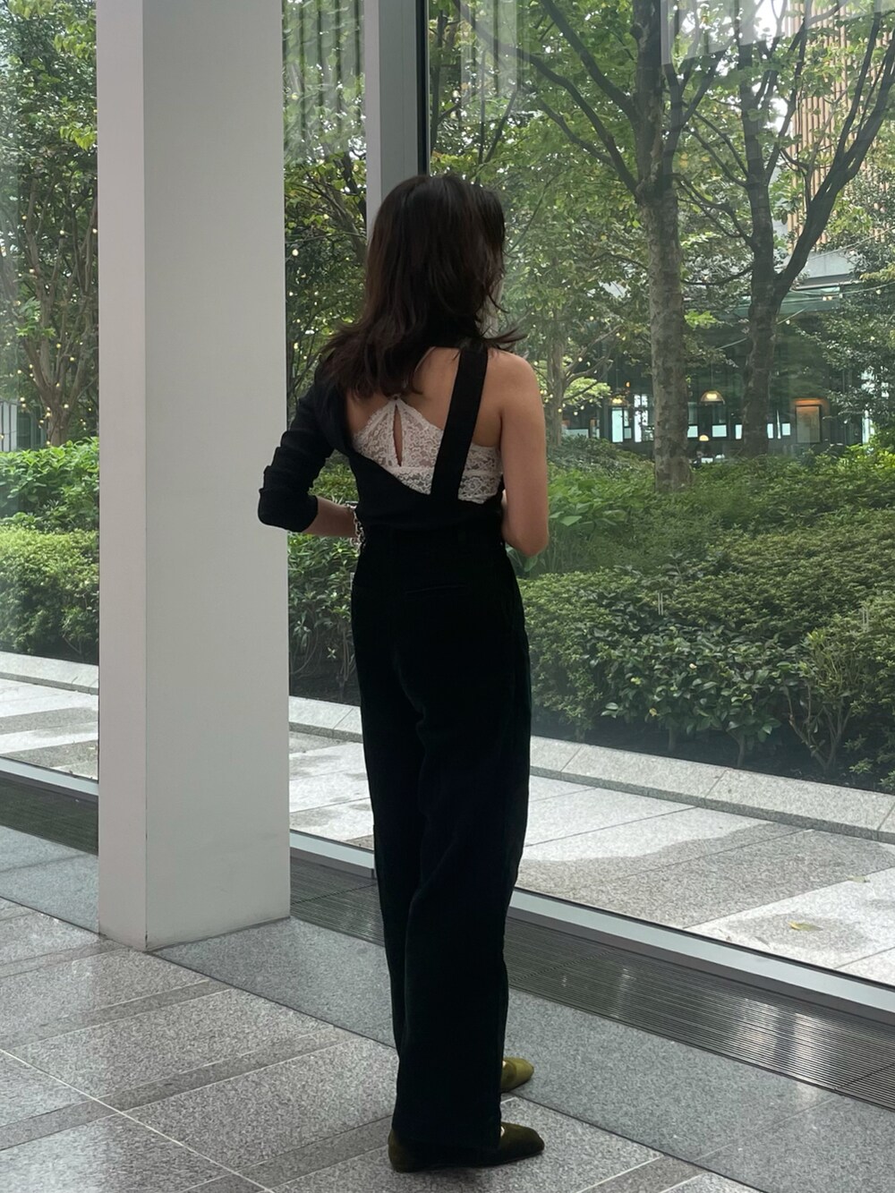 ブラック系のトップス、グリーン系のその他パンツ、ブラック系のハンドバッグを着用したレディースの秋コーディネートの4枚目の写真