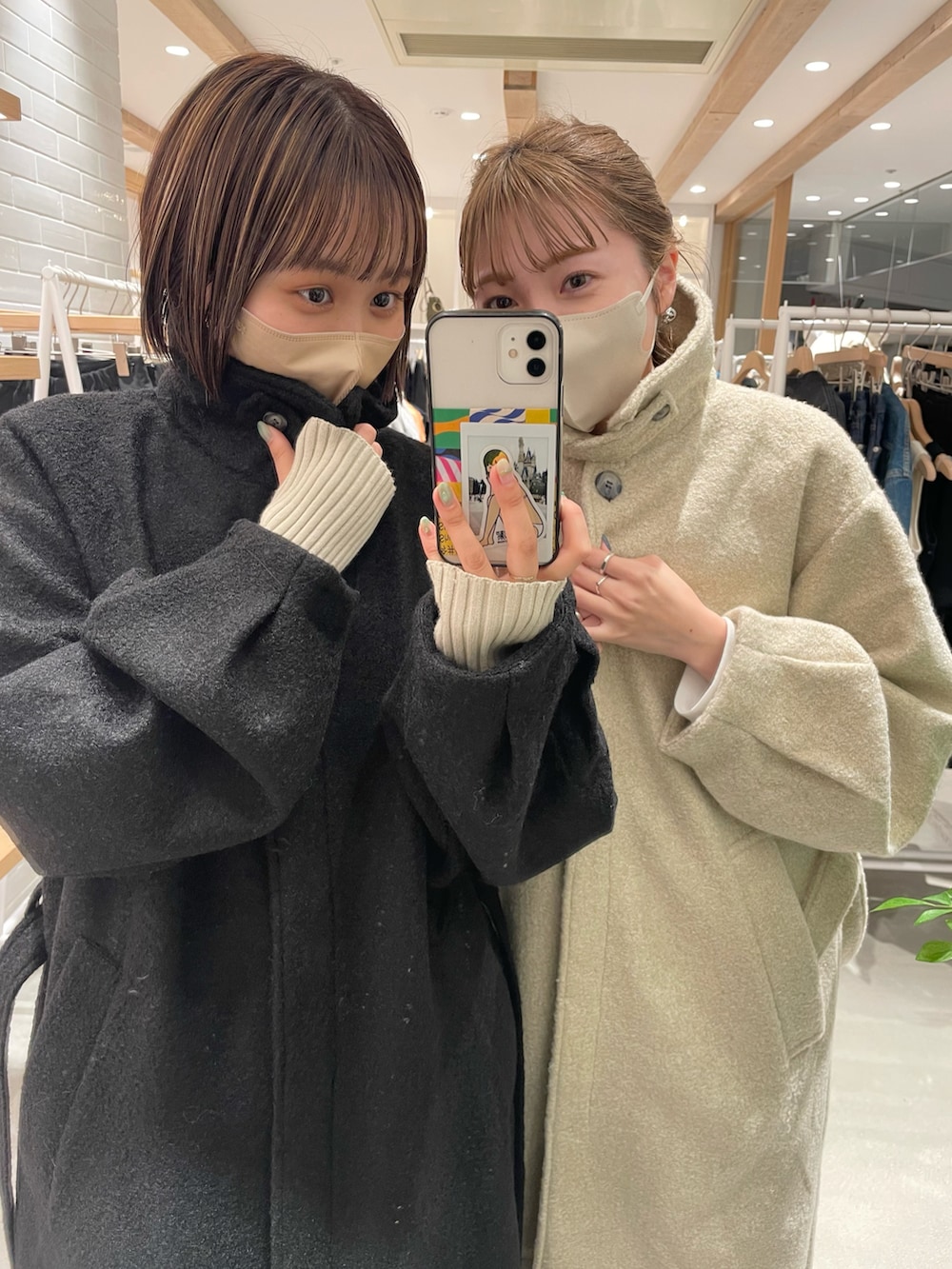 ブラック系のステンカラーコートを着用したレディースの秋コーディネートの2枚目の写真