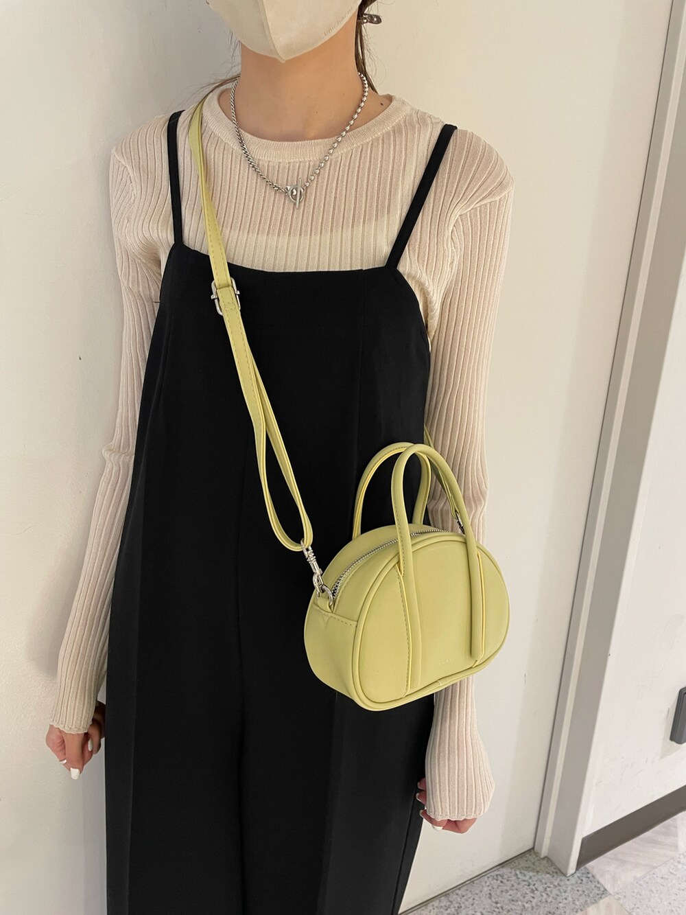 ベージュ系のブーツ、ブラック系のサロペット/オーバーオールを着用したレディースの冬コーディネートの2枚目の写真