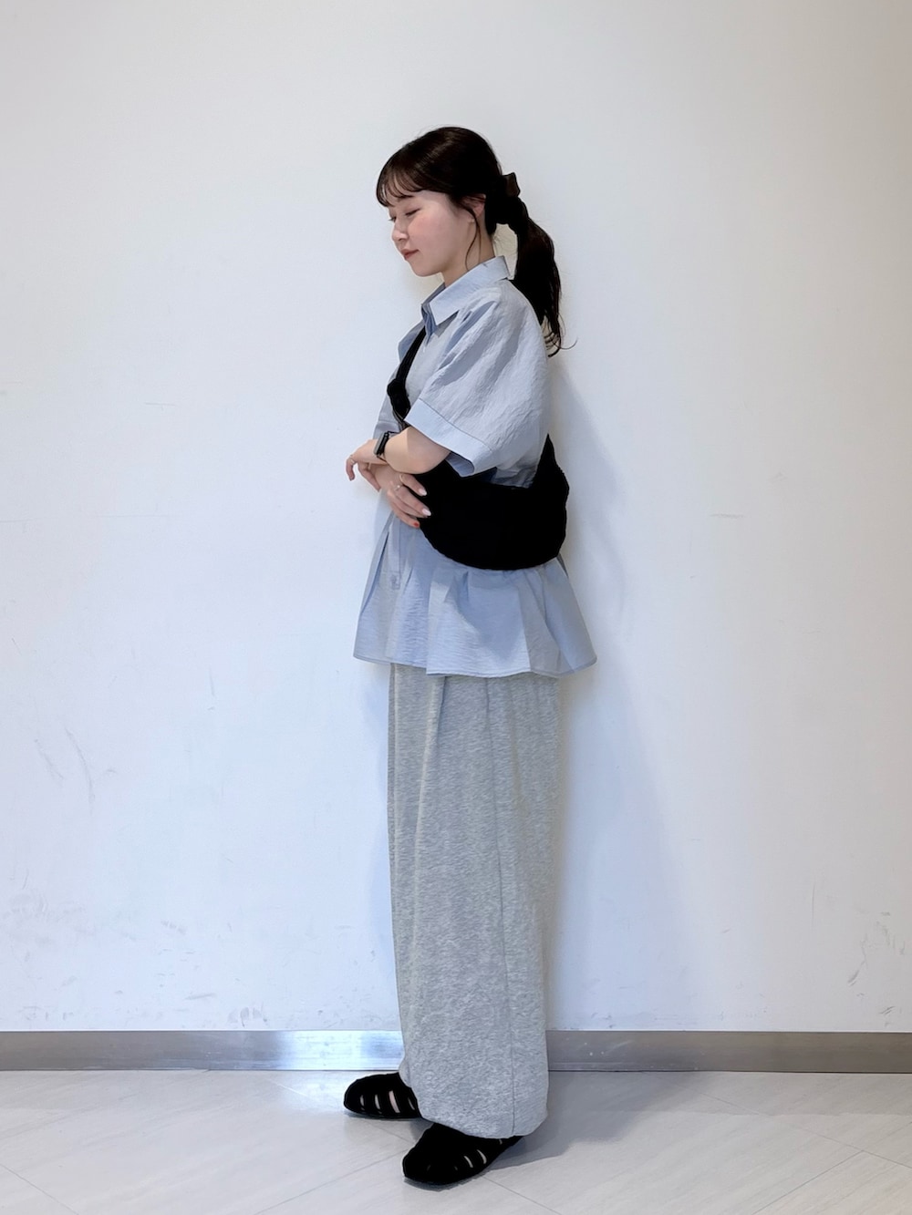 ブルー系のシャツ/ブラウス、ブラック系のショルダーバッグ、グレー系のその他パンツを着用したレディースの春コーディネートの2枚目の写真