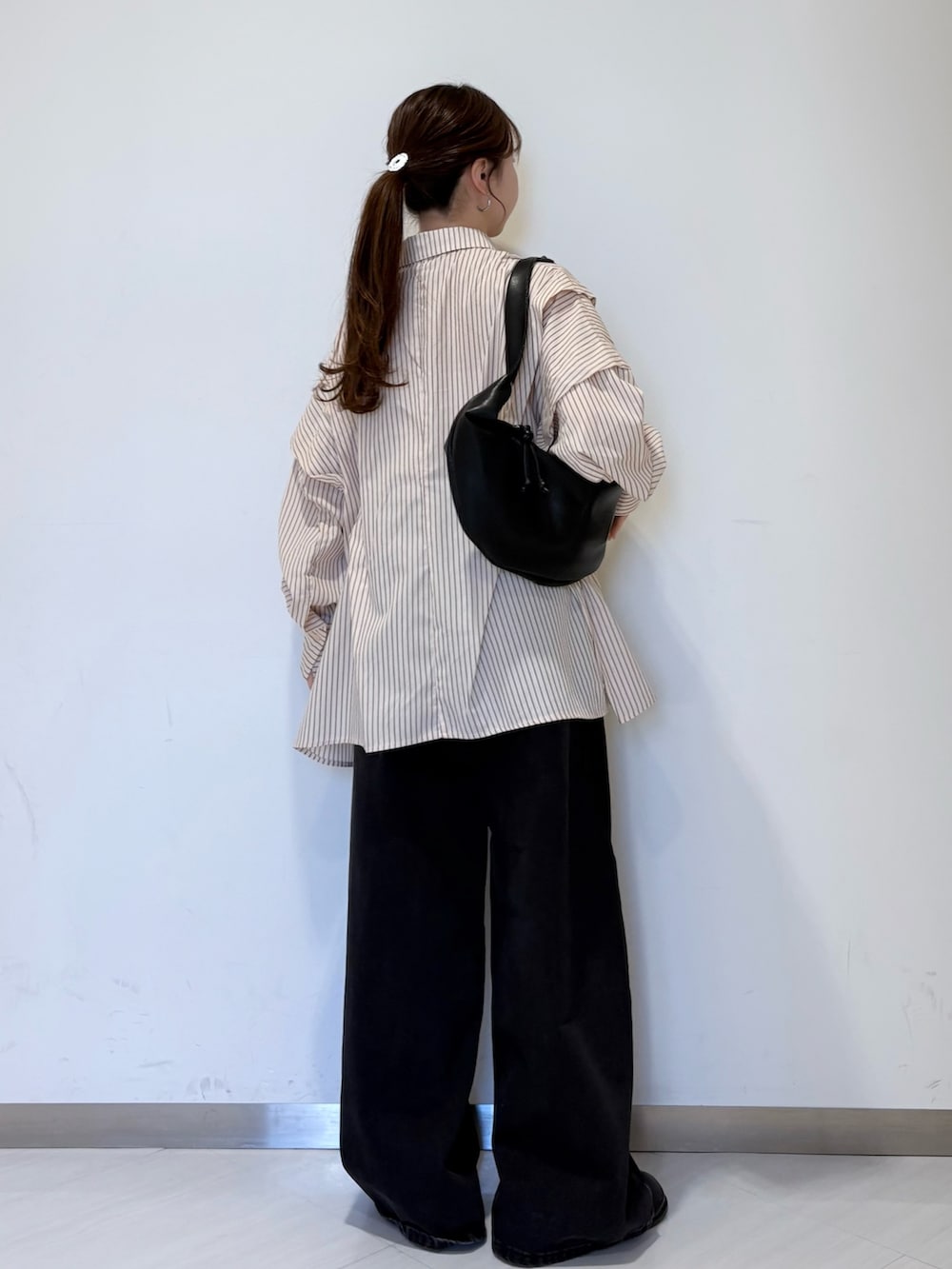 ピンク系のシャツ/ブラウス、ブラック系のショルダーバッグ、ブラック系のデニムパンツを着用したレディースの冬コーディネートの4枚目の写真