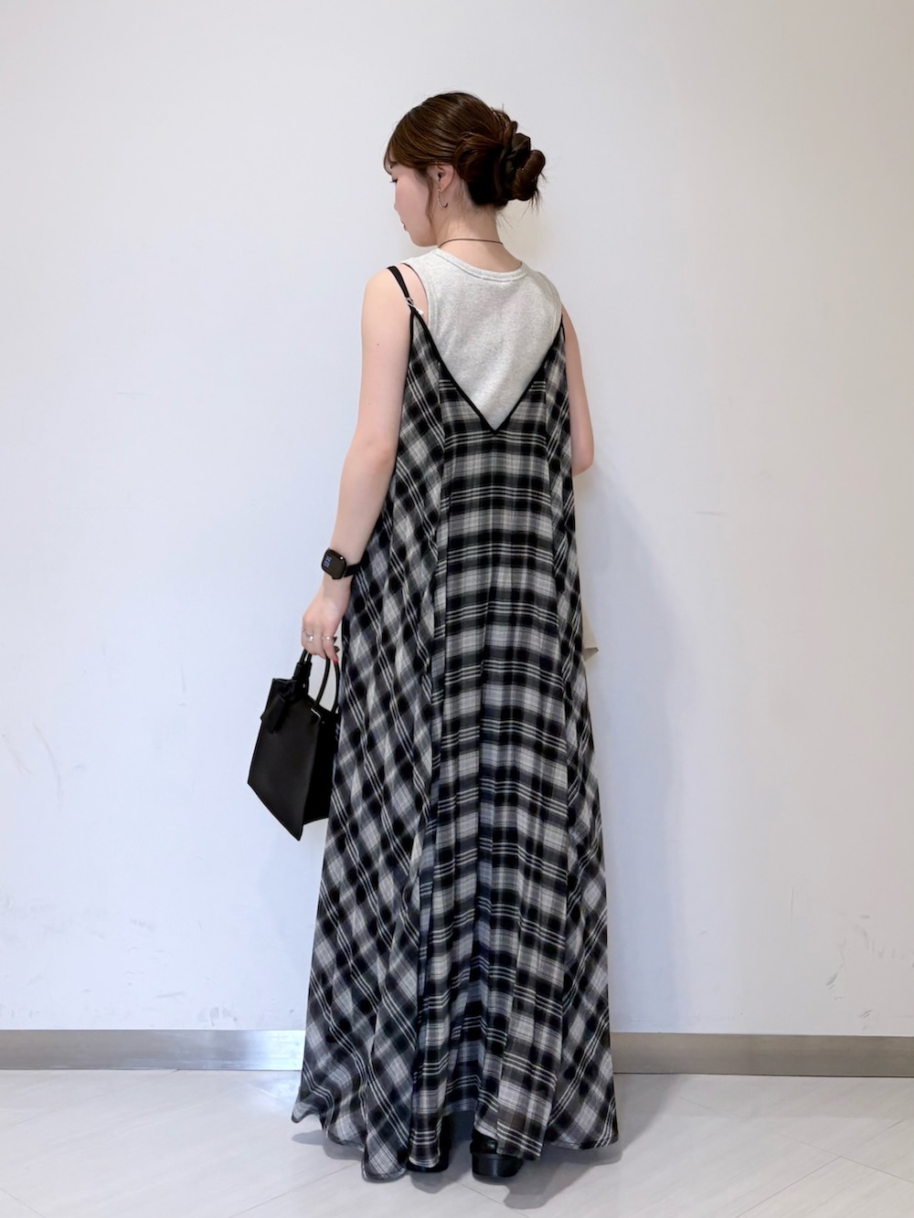 ベージュ系のタンクトップ、ブラック系のワンピース、ブラック系のハンドバッグを着用したレディースの春コーディネートの5枚目の写真