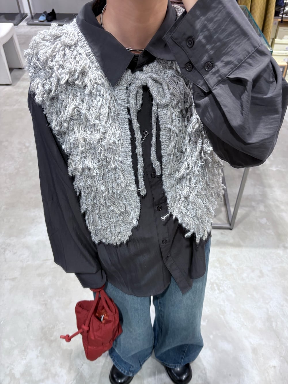 グレー系のベスト、グレー系のシャツ/ブラウス、ブルー系のデニムパンツを着用したレディースの秋コーディネートの4枚目の写真