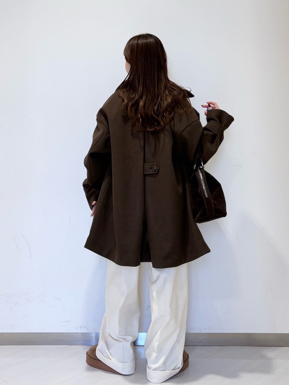 ブラウン系のその他アウター、ホワイト系のニット/セーター、ブラウン系のボストンバッグを着用したレディースの冬コーディネートの3枚目の写真