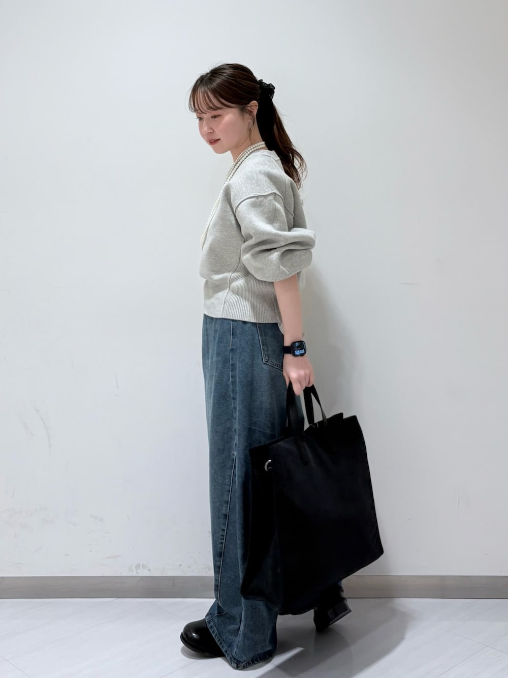 グレー系のニット/セーター、ブルー系のデニムパンツ、ブラック系のその他シューズを着用したレディースの秋コーディネートの2枚目の写真