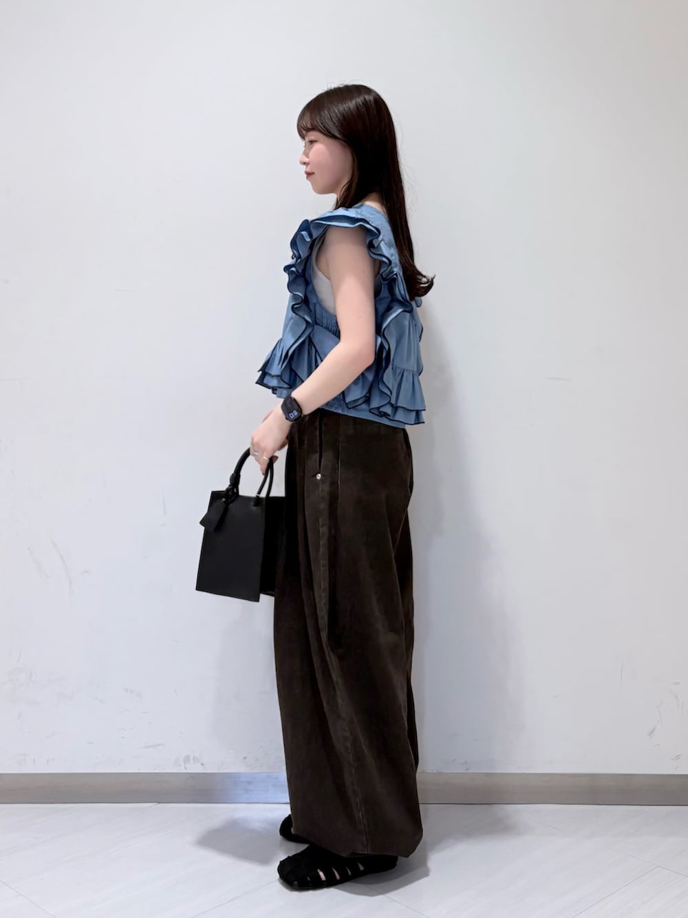 ブルー系のシャツ/ブラウス、ブラック系のサンダル、ブラウン系のその他パンツを着用したレディースの春コーディネートの2枚目の写真