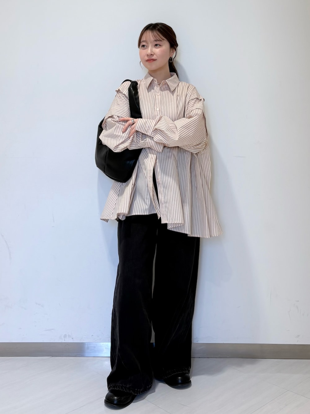 ピンク系のシャツ/ブラウス、ブラック系のショルダーバッグ、ブラック系のデニムパンツを着用したレディースの冬コーディネートの6枚目の写真