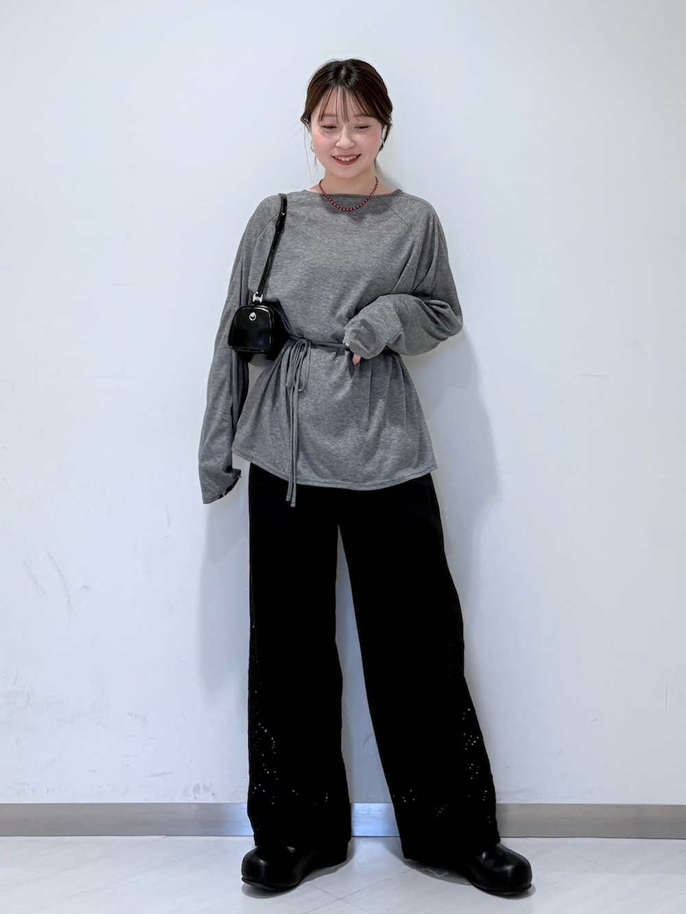 ブラック系のその他パンツ、グレー系のTシャツ/カットソー、ブラック系のショルダーバッグを着用したレディースの春コーディネートの4枚目の写真