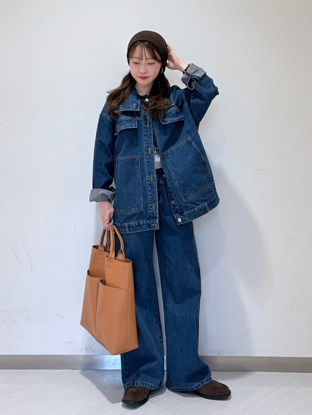 ブルー系のブルゾン、ブラウン系のローファー、イエロー系のショルダーバッグを着用したレディースの冬コーディネートの3枚目の写真