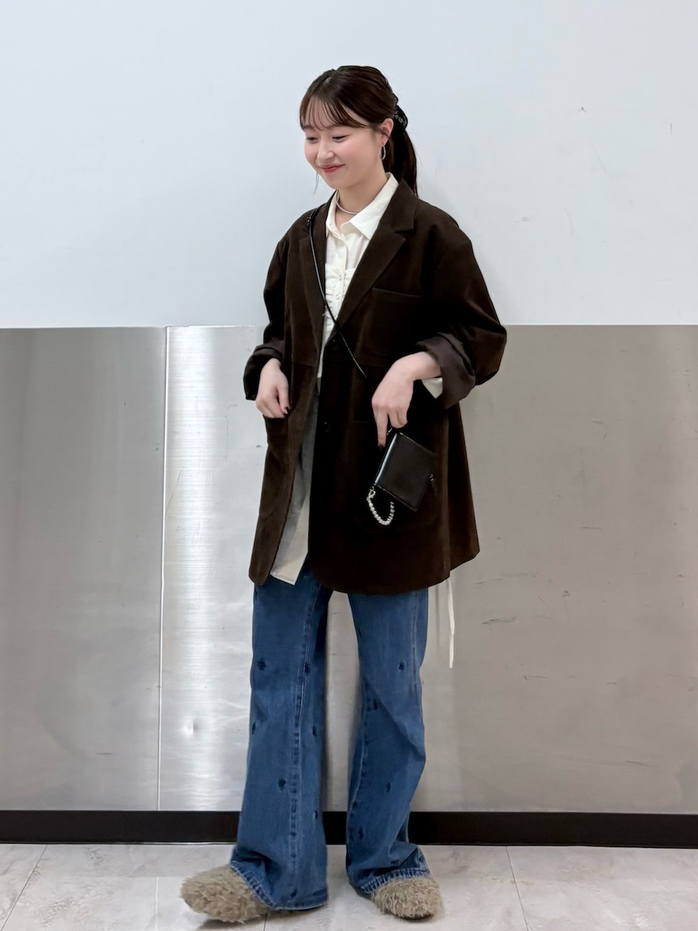 ブラウン系のその他アウター、ホワイト系のシャツ/ブラウス、ブルー系のデニムパンツを着用したレディースの秋コーディネートの2枚目の写真