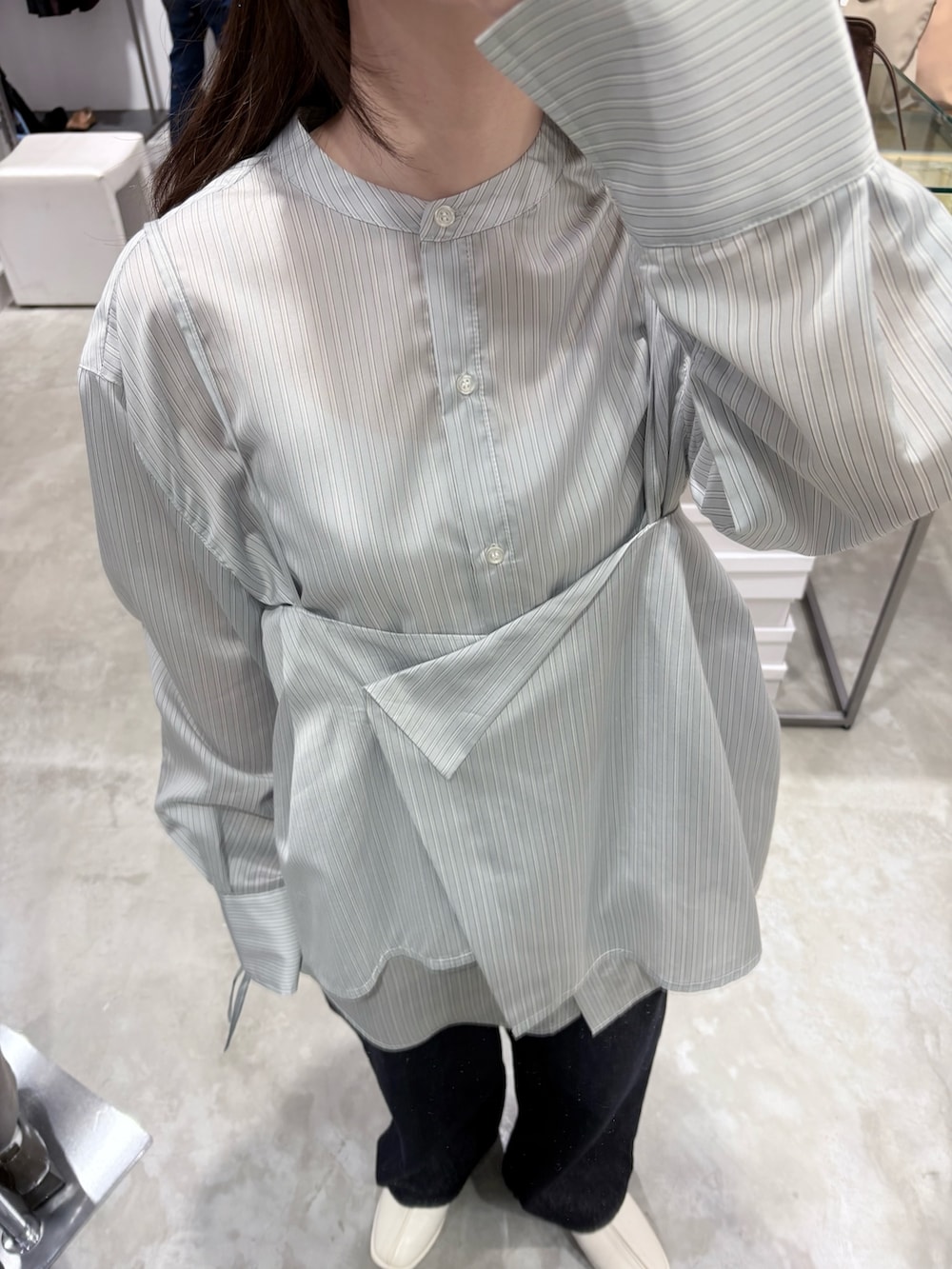 グレー系のシャツ/ブラウス、ホワイト系のパンプス、ブラウン系のボストンバッグを着用したレディースの冬コーディネートの4枚目の写真