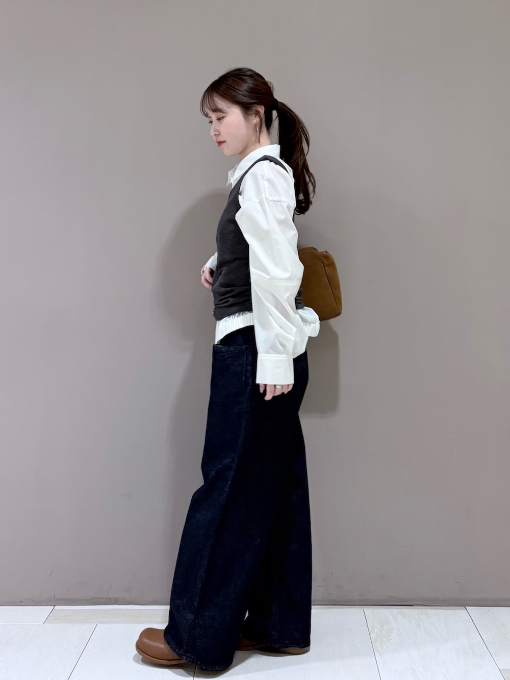 ホワイト系のシャツ/ブラウス、ブラウン系のブーツ、ブルー系のデニムパンツを着用したレディースの冬コーディネートの3枚目の写真