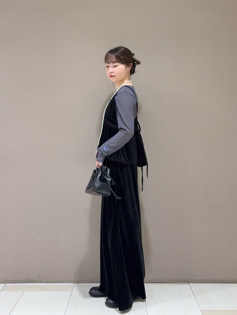グレー系のTシャツ/カットソー、ブラック系のセットアップ、ブラック系のハンドバッグを着用したレディースの秋コーディネートの2枚目の写真