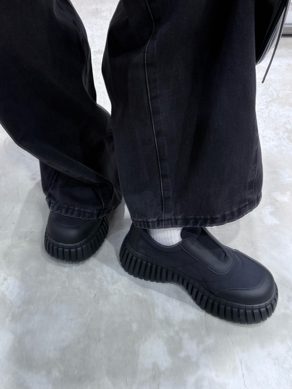 ブラウン系のニット/セーター、グレー系のタンクトップ、ブラック系のデニムパンツを着用したレディースの冬コーディネートの4枚目の写真