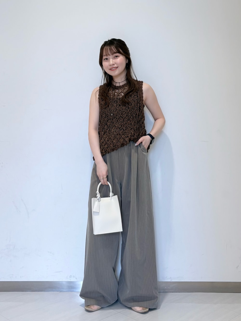 ホワイト系のニット/セーター、ブラウン系のその他パンツ、ブラック系のキャミソールを着用したレディースの春コーディネートの2枚目の写真