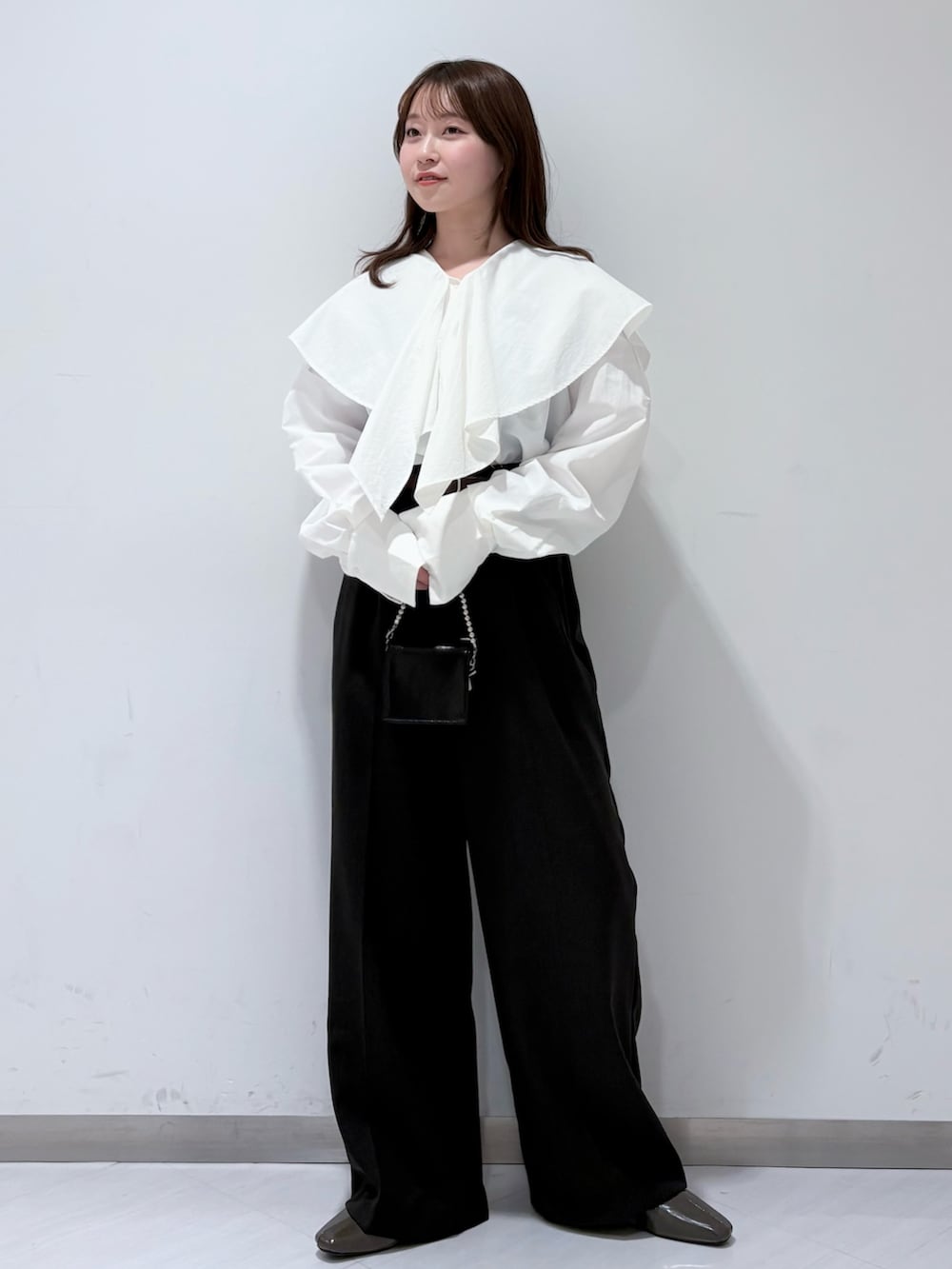 ホワイト系のシャツ/ブラウス、グリーン系のパンプス、グレー系のその他パンツを着用したレディースの春コーディネートの2枚目の写真