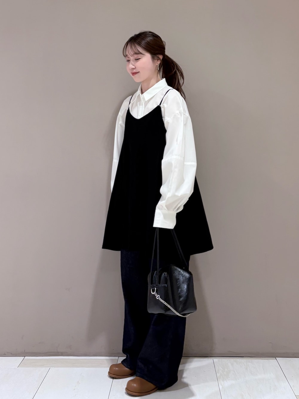 ホワイト系のシャツ/ブラウス、ブラック系のワンピース、ブラウン系のブーツを着用したレディースの冬コーディネートの3枚目の写真