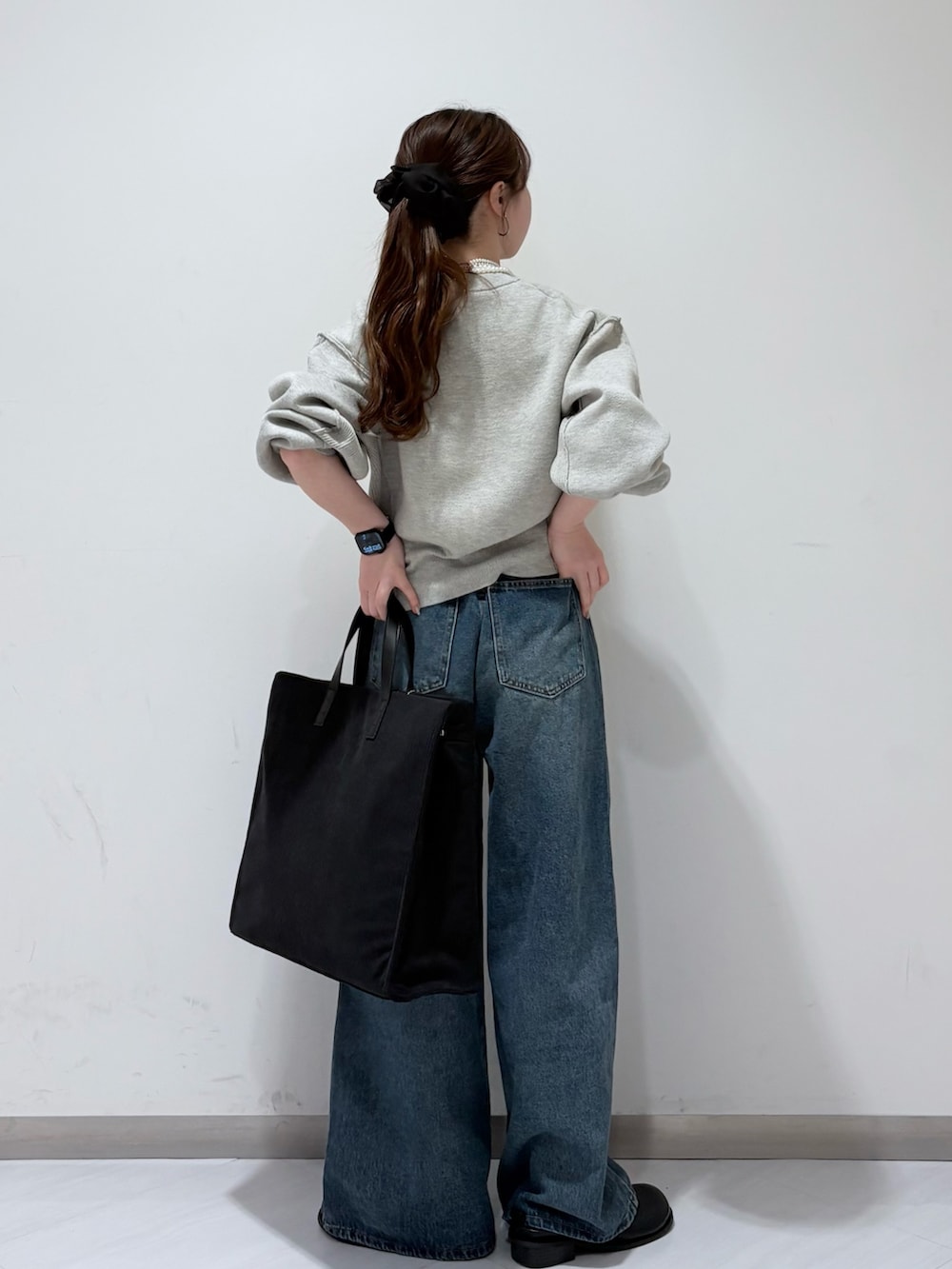 グレー系のニット/セーター、ブルー系のデニムパンツ、ブラック系のその他シューズを着用したレディースの秋コーディネートの3枚目の写真