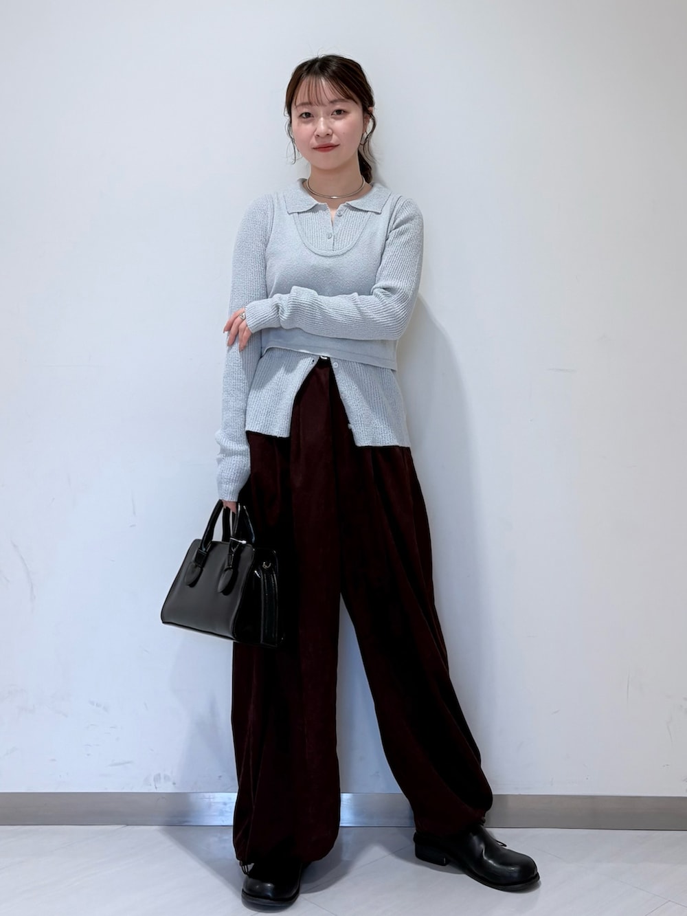 ブルー系のニット/セーター、ブラック系のその他シューズ、ブラック系のボストンバッグを着用したレディースの冬コーディネートの2枚目の写真