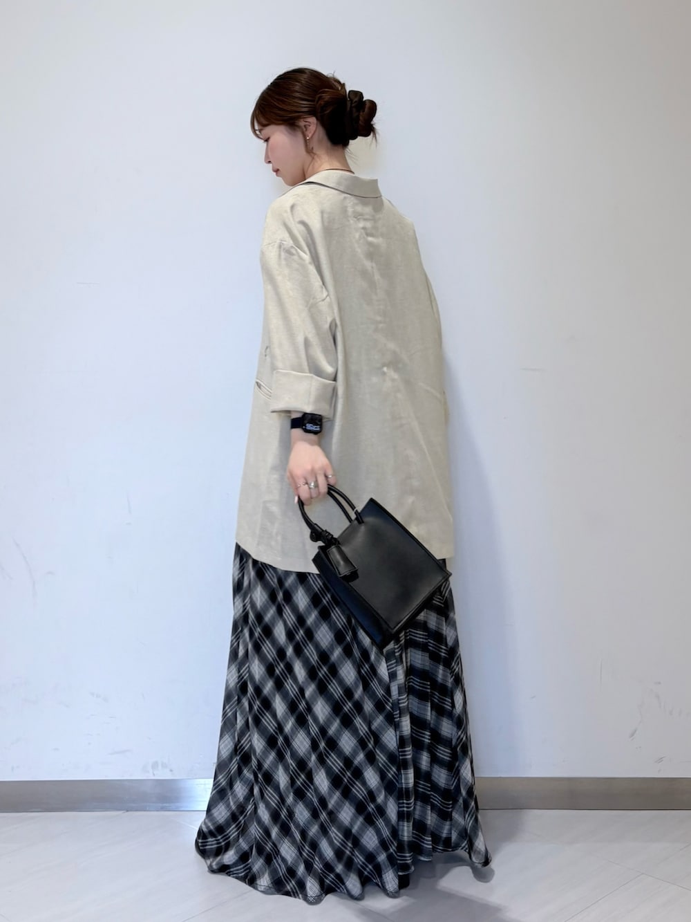 ベージュ系のタンクトップ、ブラック系のワンピース、ブラック系のハンドバッグを着用したレディースの春コーディネートの3枚目の写真