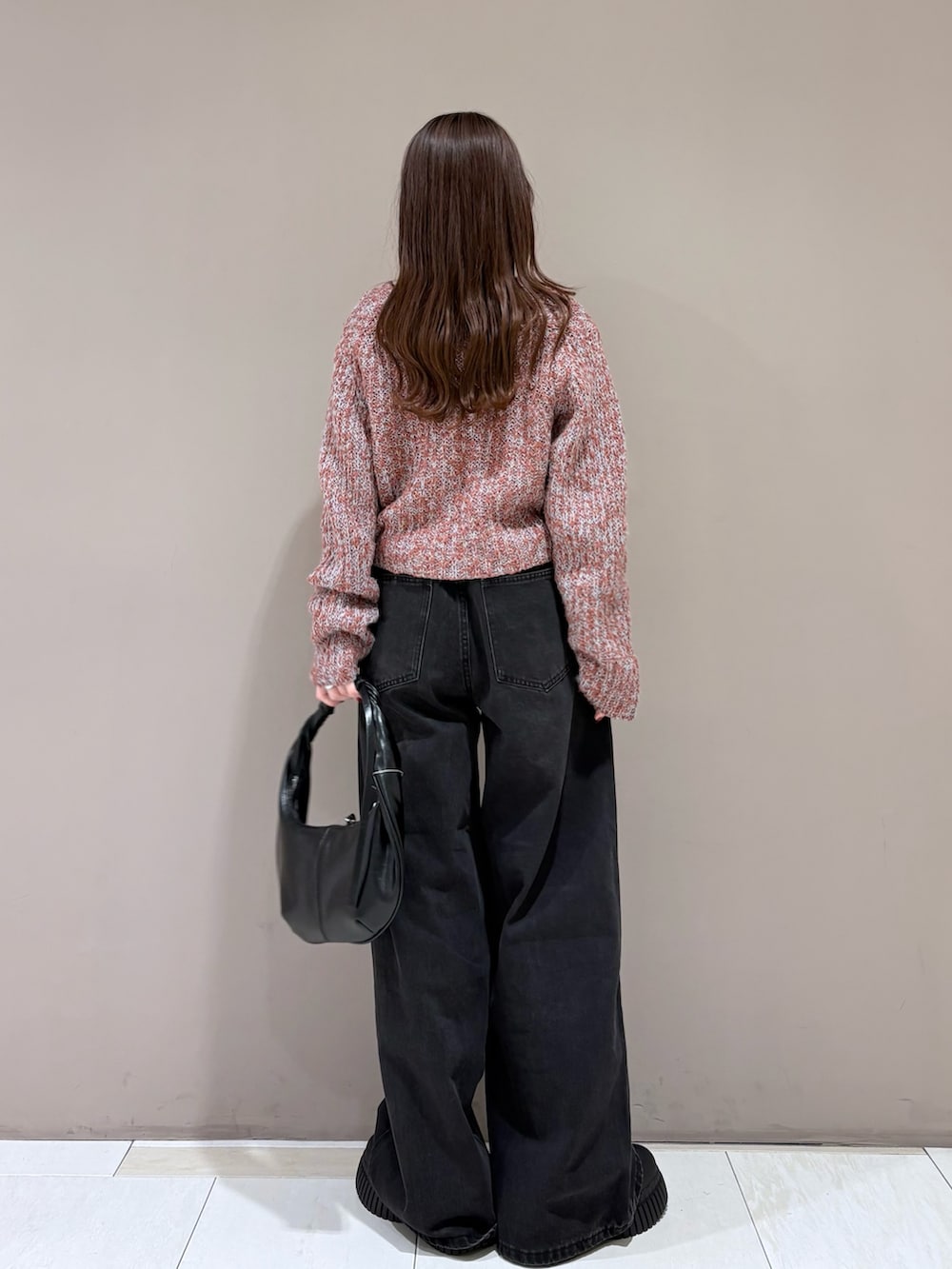 ブラウン系のニット/セーター、グレー系のタンクトップ、ブラック系のデニムパンツを着用したレディースの冬コーディネートの3枚目の写真