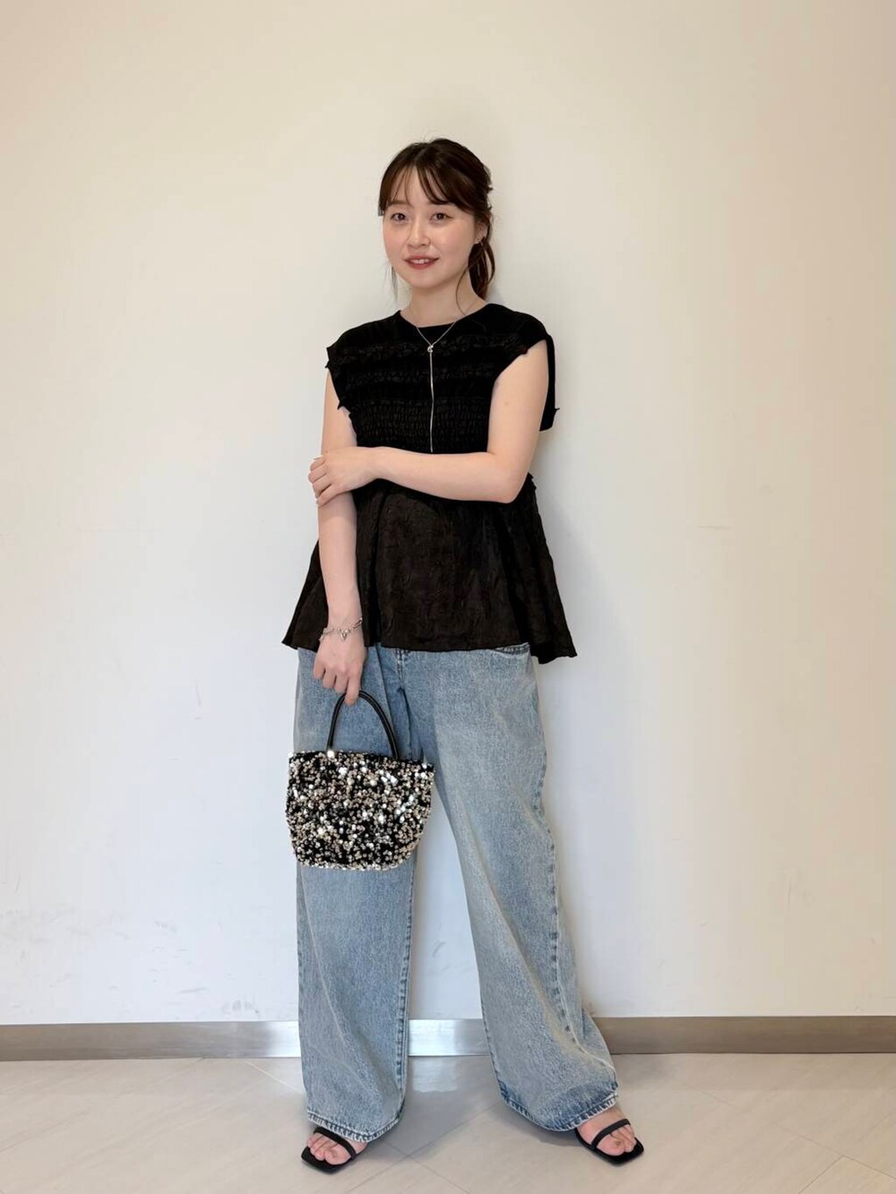ブルー系のデニムパンツ、シルバー系のショルダーバッグ、ブルー系のサンダルを着用したレディースの夏コーディネートの2枚目の写真
