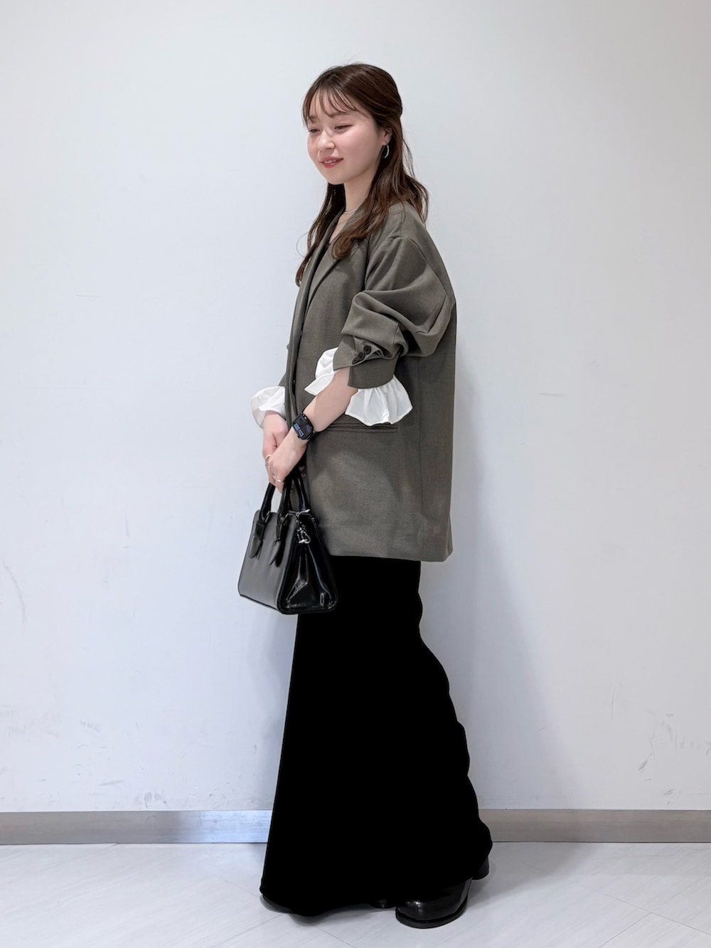 ブラック系のサンダル、グレー系のその他アウター、ブラック系のボストンバッグを着用したレディースの春コーディネートの3枚目の写真