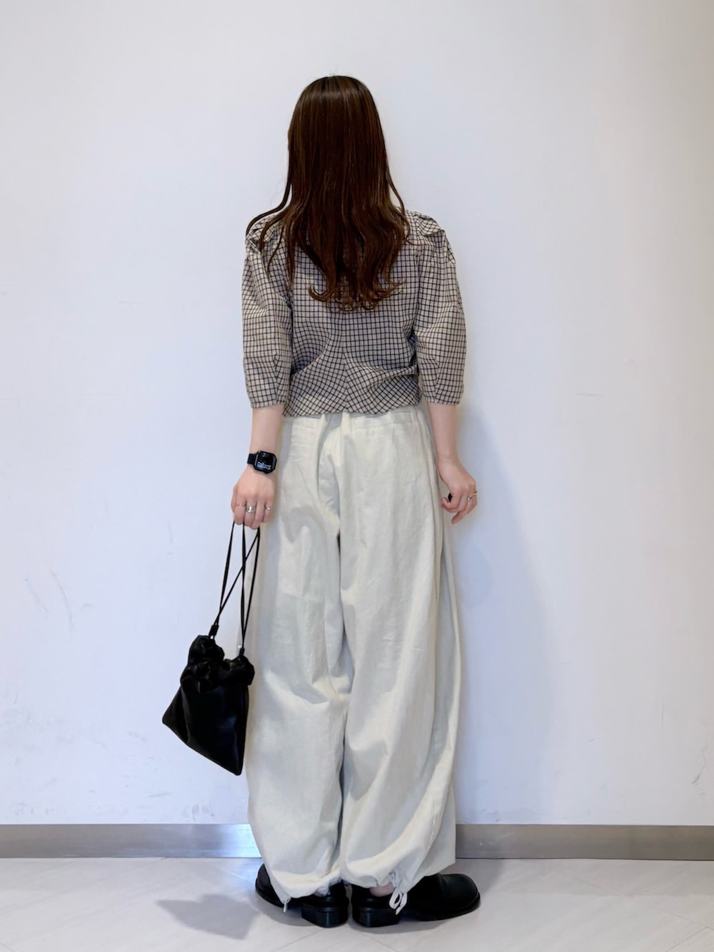 ホワイト系のその他パンツ、ブラック系のその他シューズ、ブラック系のショルダーバッグを着用したレディースの春コーディネートの3枚目の写真