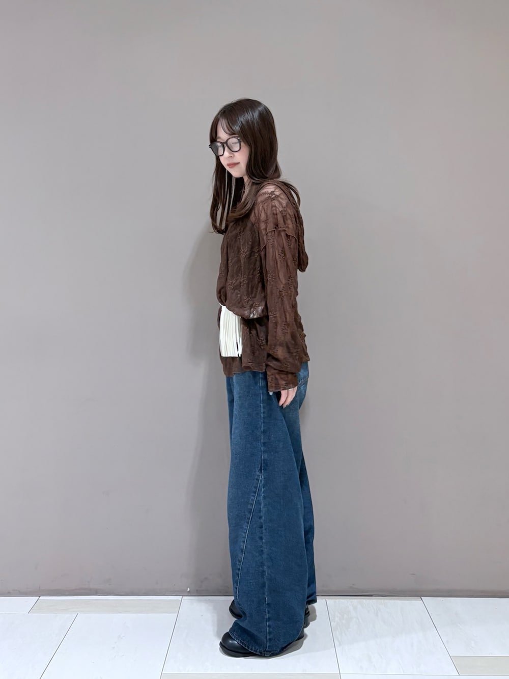 ブラウン系のTシャツ/カットソー、ブラック系のサンダル、ブルー系のデニムパンツを着用したレディースの夏コーディネートの4枚目の写真