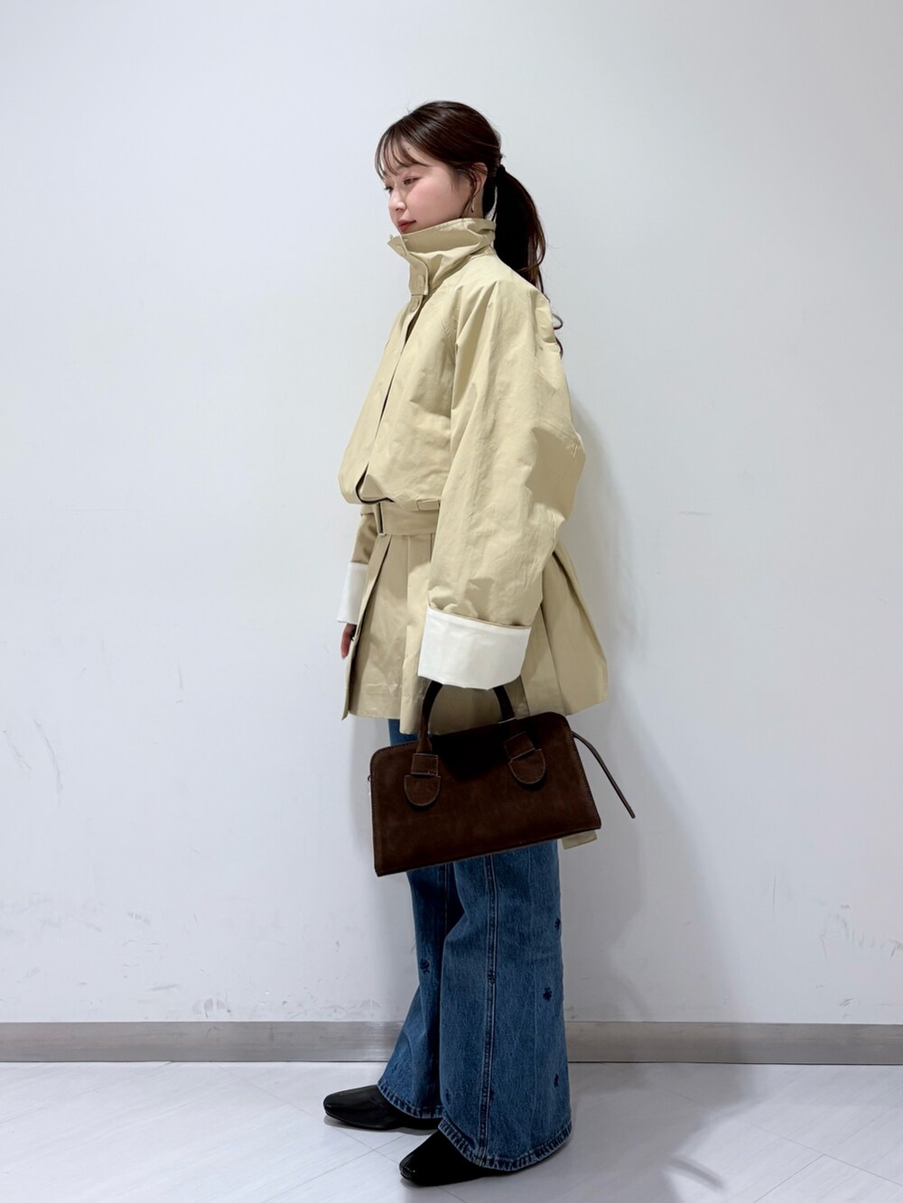 ベージュ系のその他アウター、ブラック系のパンプス、ブラウン系のボストンバッグを着用したレディースの冬コーディネートの2枚目の写真