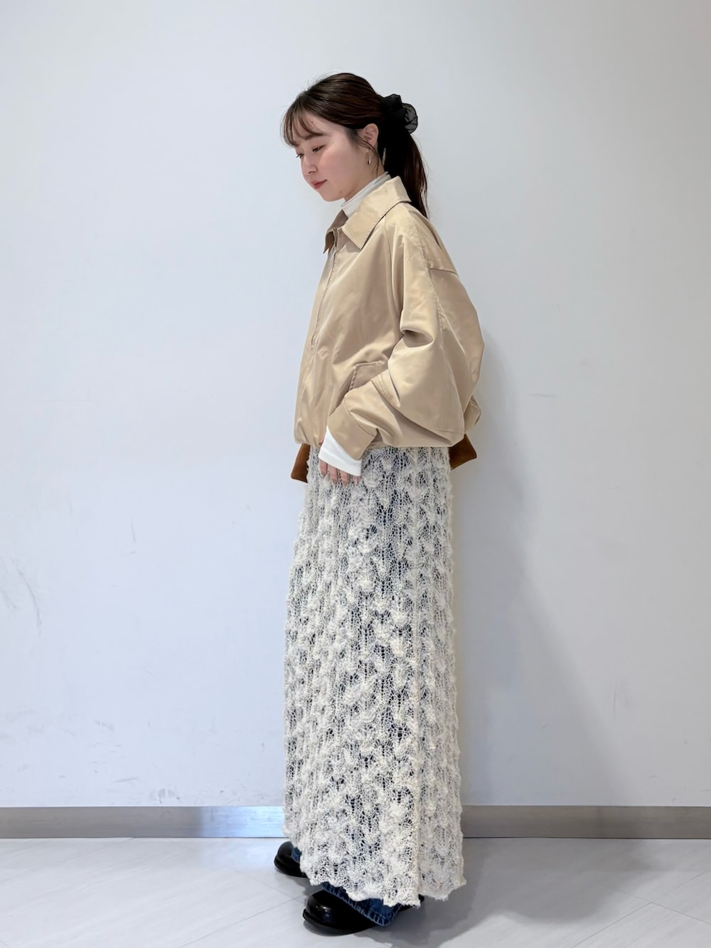 ベージュ系のブルゾン、ホワイト系のTシャツ/カットソー、ホワイト系のスカートを着用したレディースの秋コーディネートの2枚目の写真