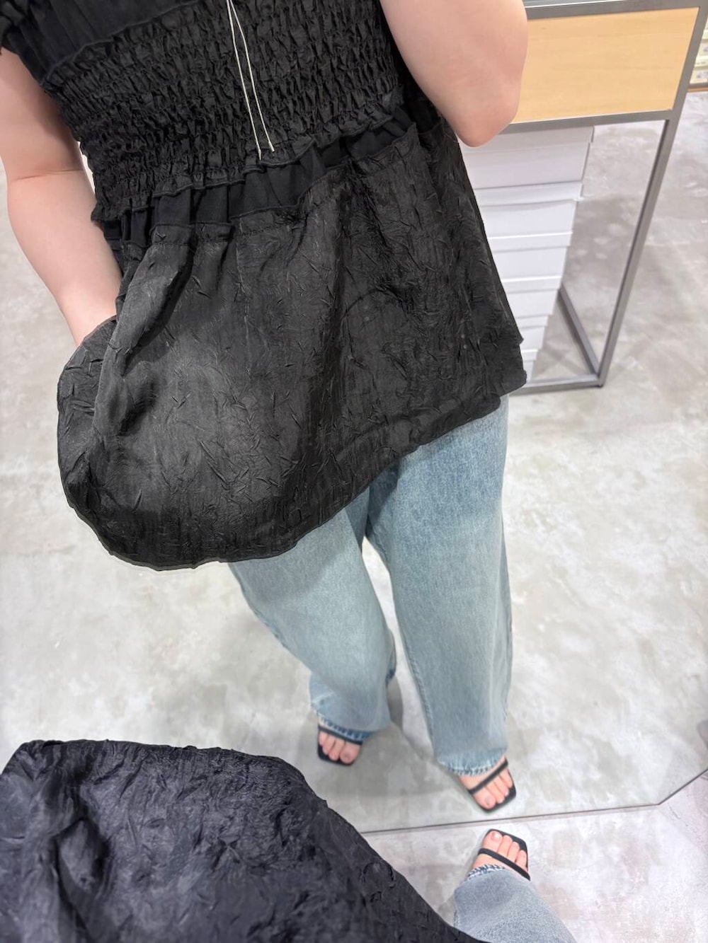 ブルー系のデニムパンツ、シルバー系のショルダーバッグ、ブルー系のサンダルを着用したレディースの夏コーディネートの4枚目の写真