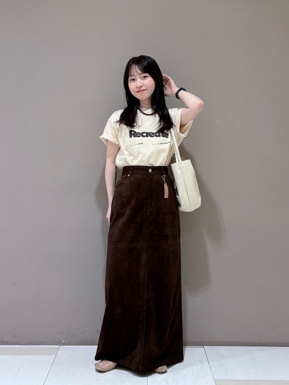 ブラウン系のスカート、ホワイト系のショルダーバッグ、ホワイト系のTシャツ/カットソーを着用したレディースの夏コーディネートの4枚目の写真