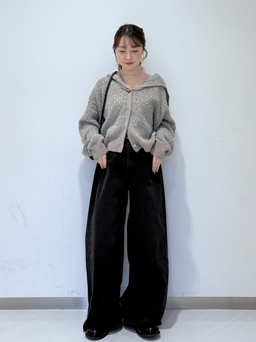 グレー系のニット/セーター、ブラック系のその他シューズ、ブラック系のデニムパンツを着用したレディースの秋コーディネートの5枚目の写真