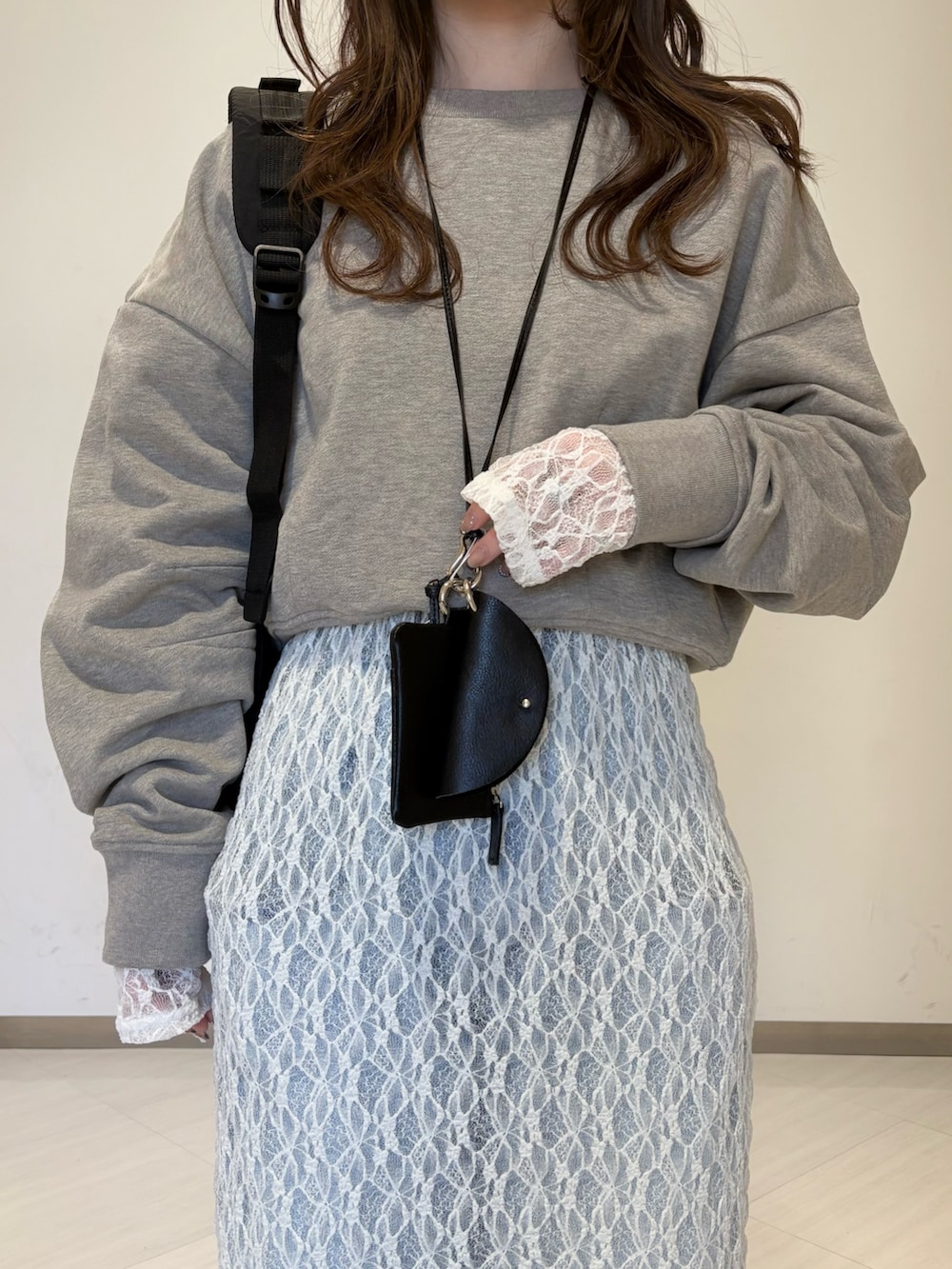 ベージュ系のスウェット、ブラック系のショルダーバッグ、ブルー系のデニムパンツを着用したレディースの春コーディネートの3枚目の写真