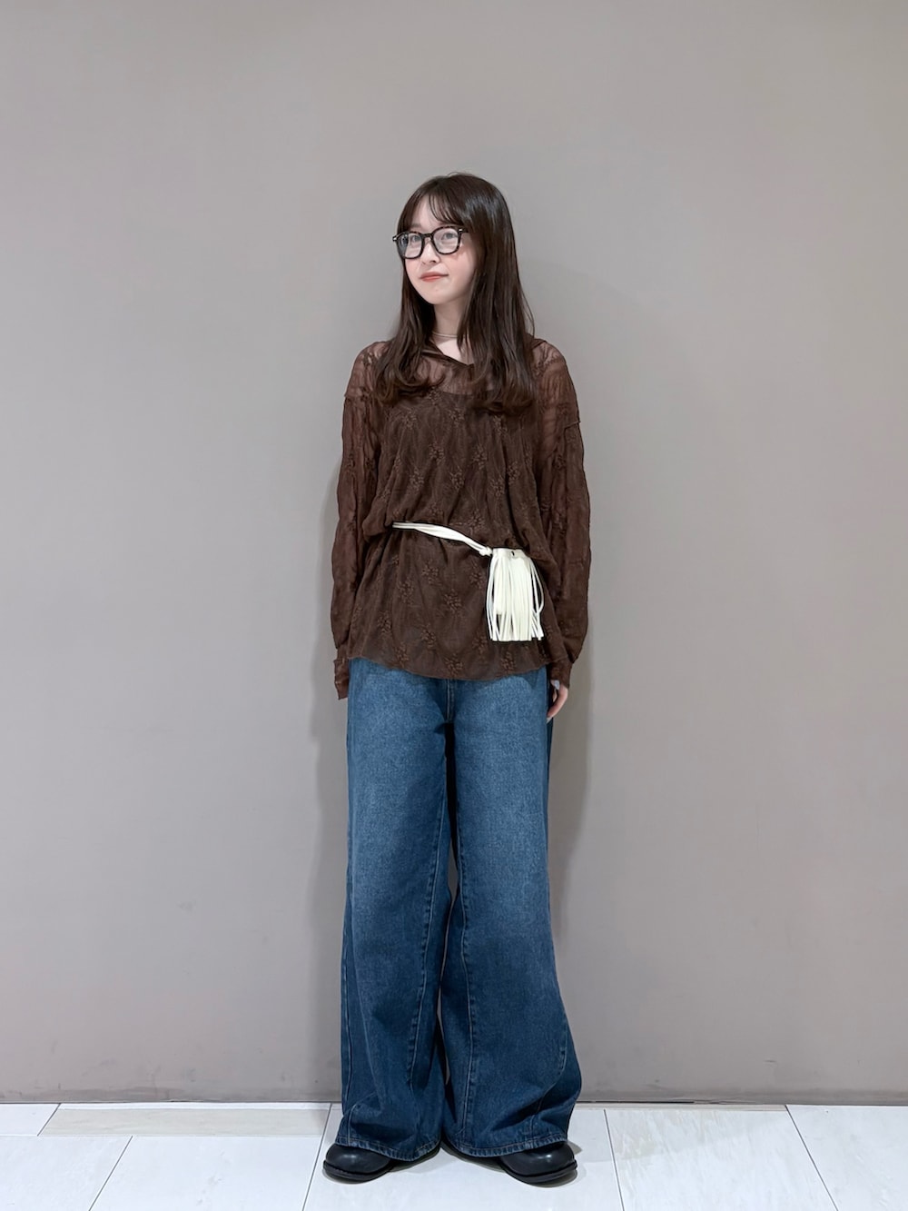 ブラウン系のTシャツ/カットソー、ブラック系のサンダル、ブルー系のデニムパンツを着用したレディースの夏コーディネートの3枚目の写真