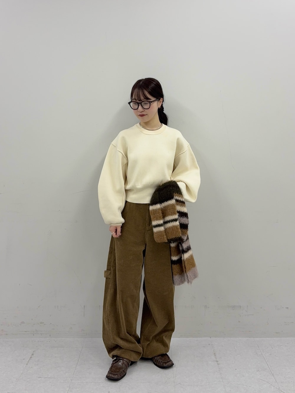 ホワイト系のニット/セーター、ブラウン系のその他パンツ、ブラウン系のローファーを着用したレディースの秋コーディネートの2枚目の写真