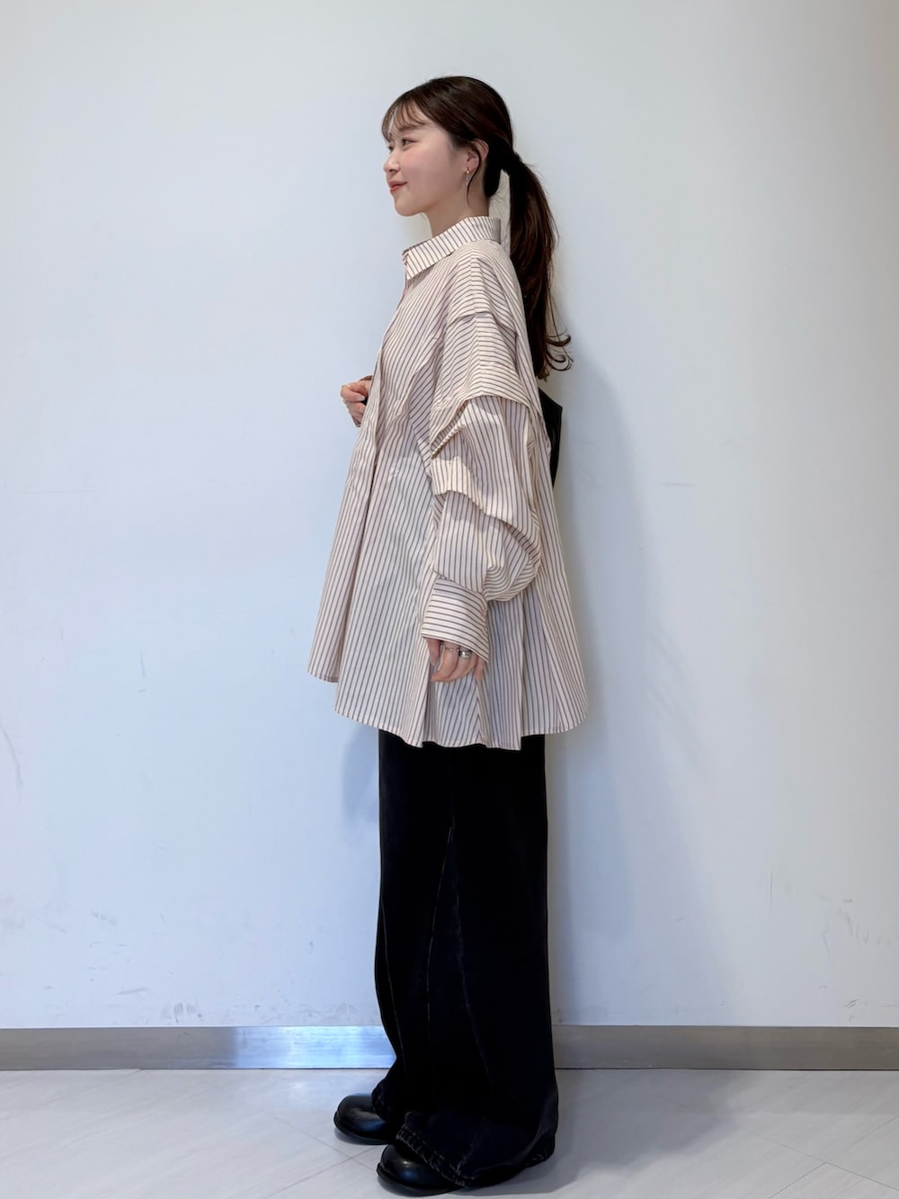 ピンク系のシャツ/ブラウス、ブラック系のショルダーバッグ、ブラック系のデニムパンツを着用したレディースの冬コーディネートの3枚目の写真