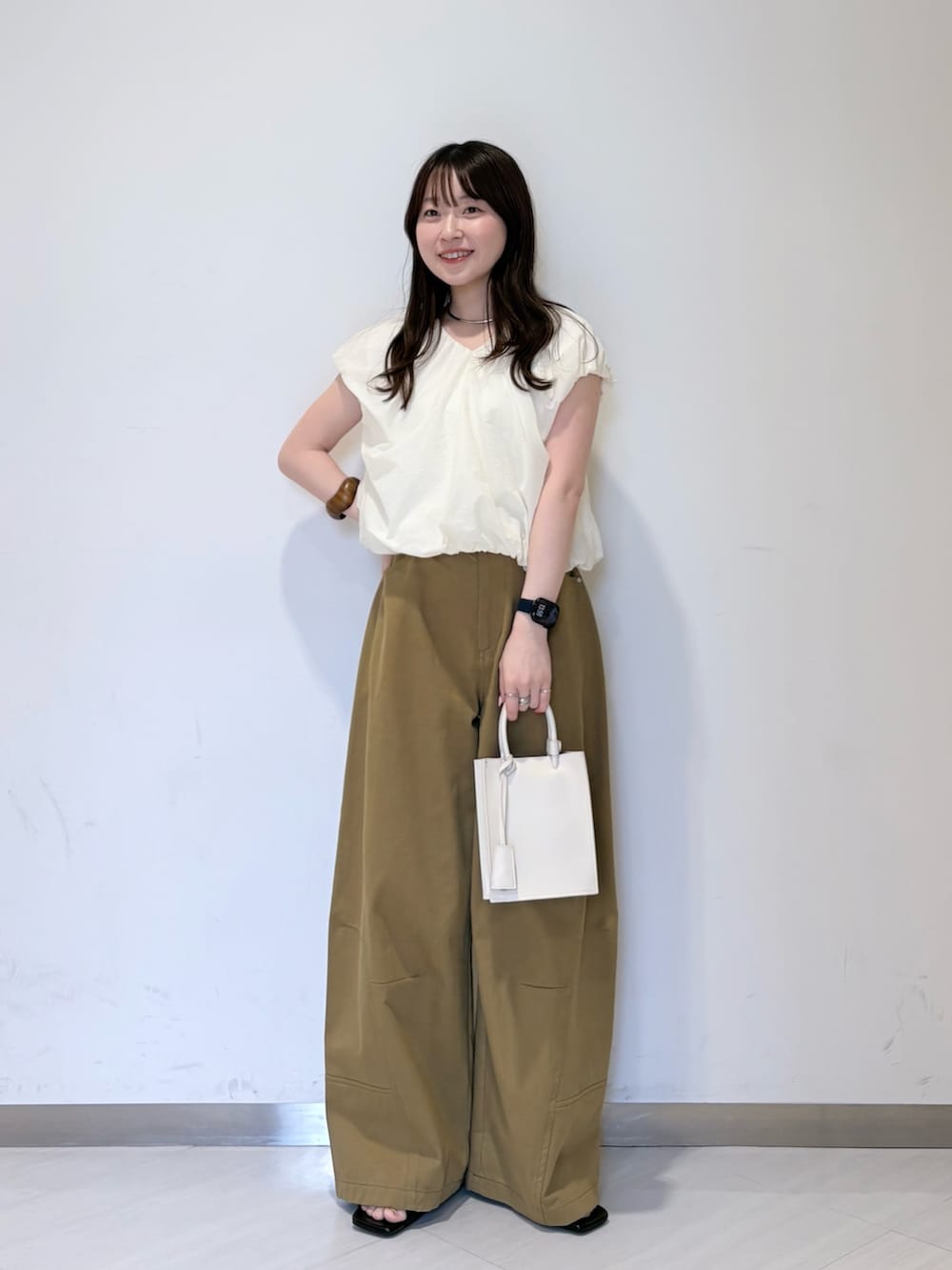 ホワイト系のシャツ/ブラウス、グリーン系のその他パンツ、ホワイト系のハンドバッグを着用したレディースの春コーディネートの4枚目の写真