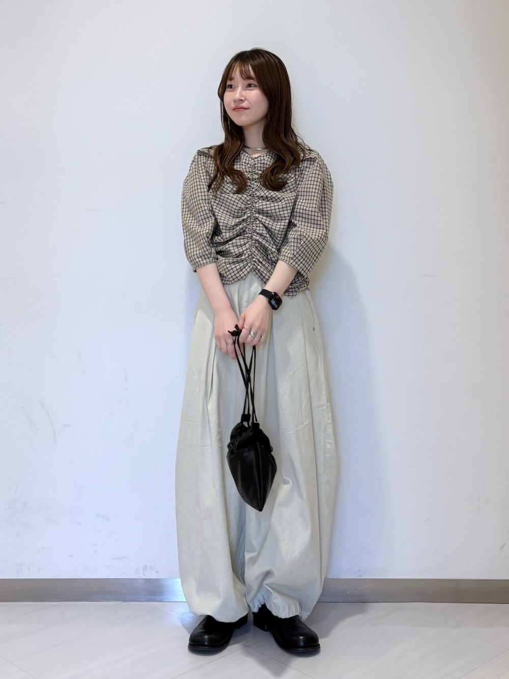 ホワイト系のその他パンツ、ブラック系のその他シューズ、ブラック系のショルダーバッグを着用したレディースの春コーディネートの2枚目の写真