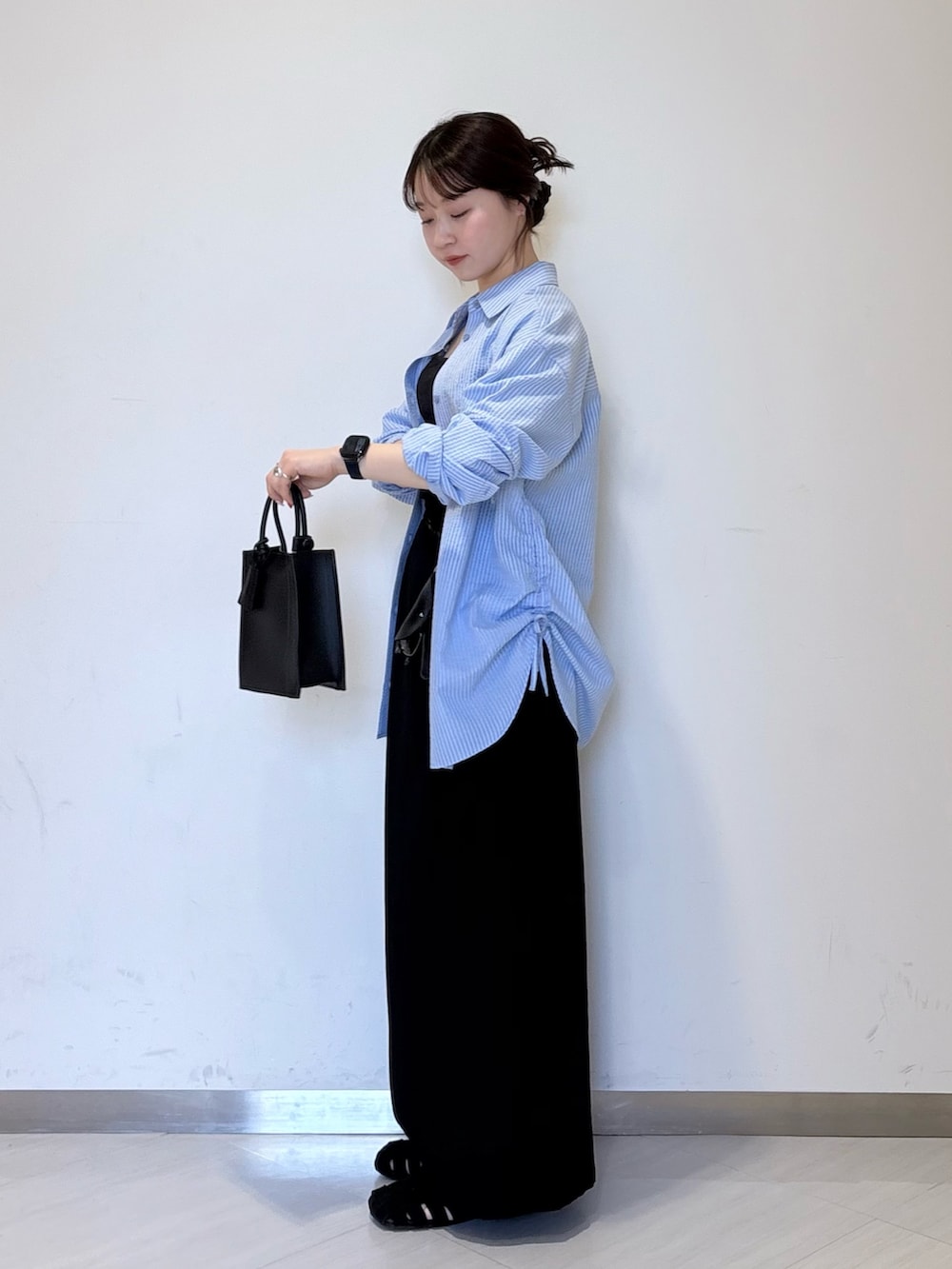 ブルー系のシャツ/ブラウス、ブラック系のショルダーバッグ、ブラック系のハンドバッグを着用したレディースの春コーディネートの4枚目の写真