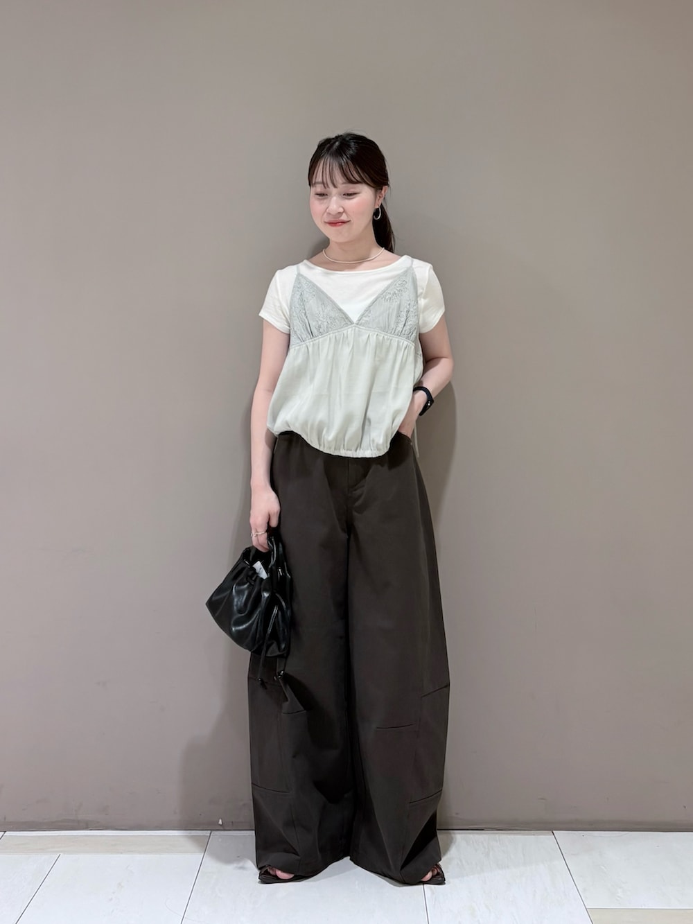 ホワイト系のTシャツ/カットソー、グレー系のその他トップス、ブラック系のハンドバッグを着用したレディースの夏コーディネートの4枚目の写真