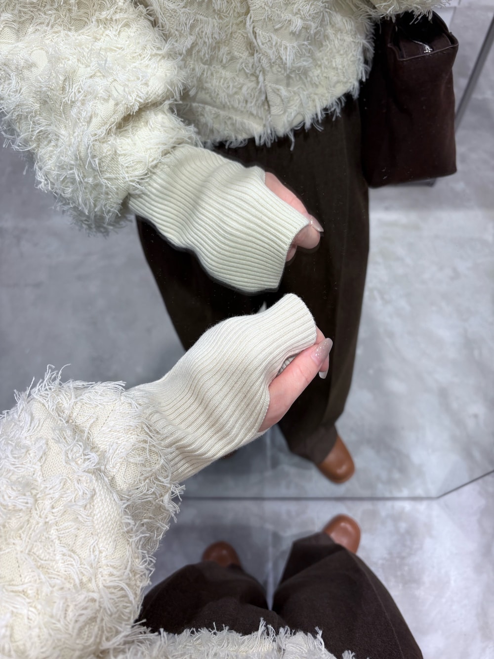 ホワイト系のカーディガン/ボレロ、ブラウン系のその他パンツ、ブラウン系のボストンバッグを着用したレディースの冬コーディネートの4枚目の写真