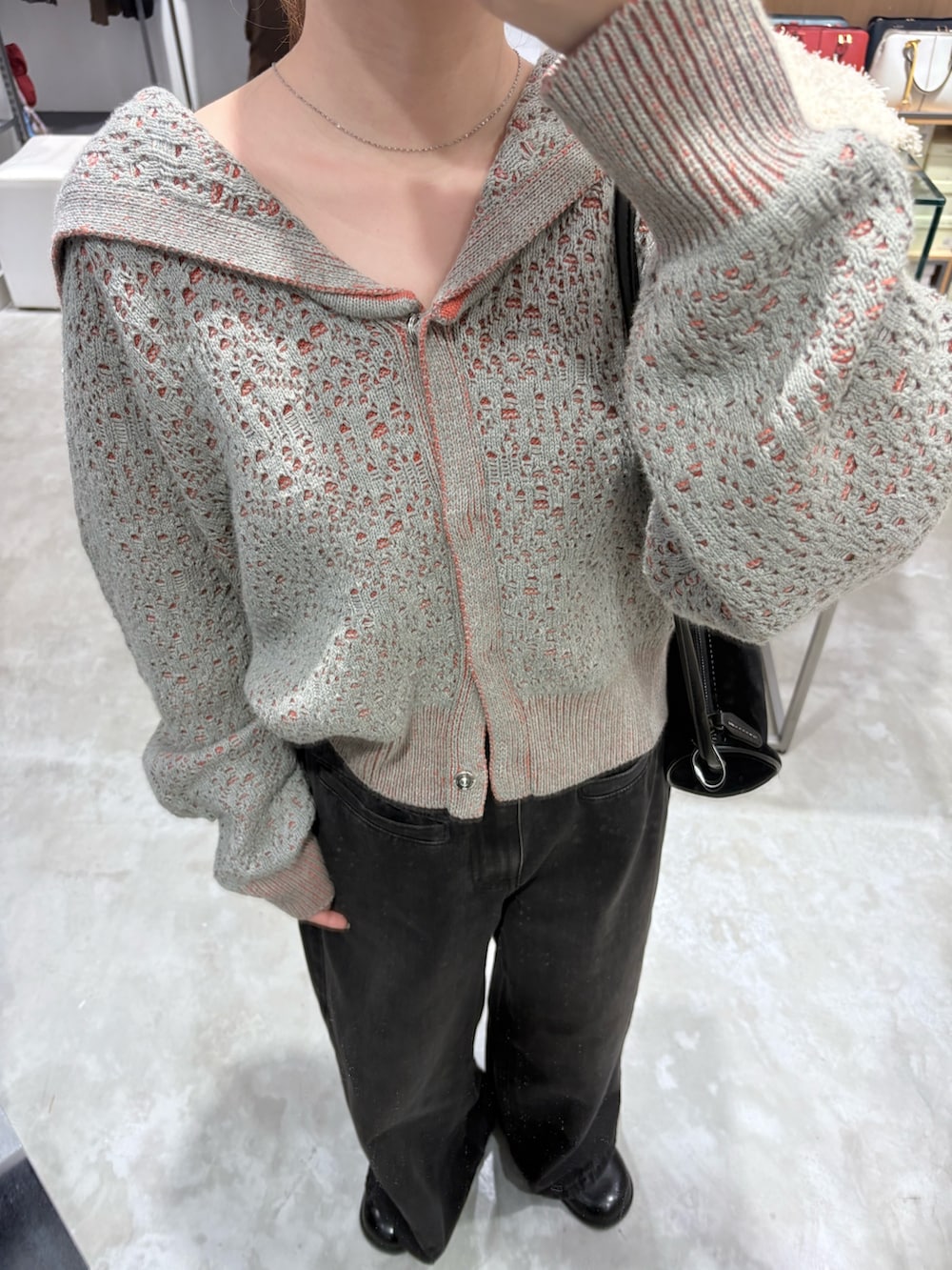 グレー系のニット/セーター、ブラック系のその他シューズ、ブラック系のデニムパンツを着用したレディースの秋コーディネートの3枚目の写真