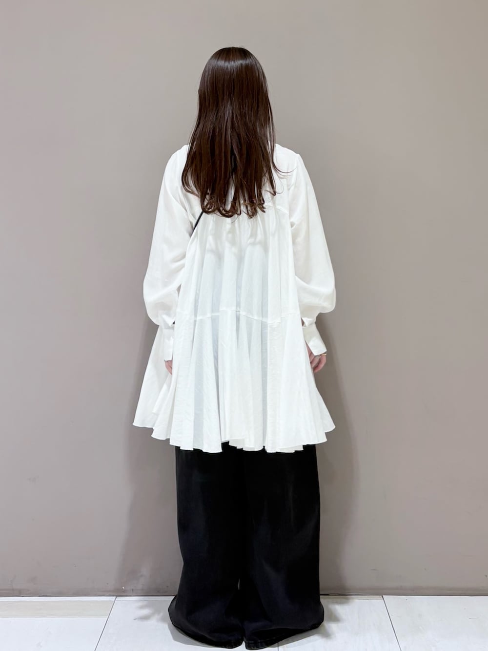 ホワイト系のワンピース、ブラック系のその他シューズ、ブラック系のデニムパンツを着用したレディースの冬コーディネートの3枚目の写真