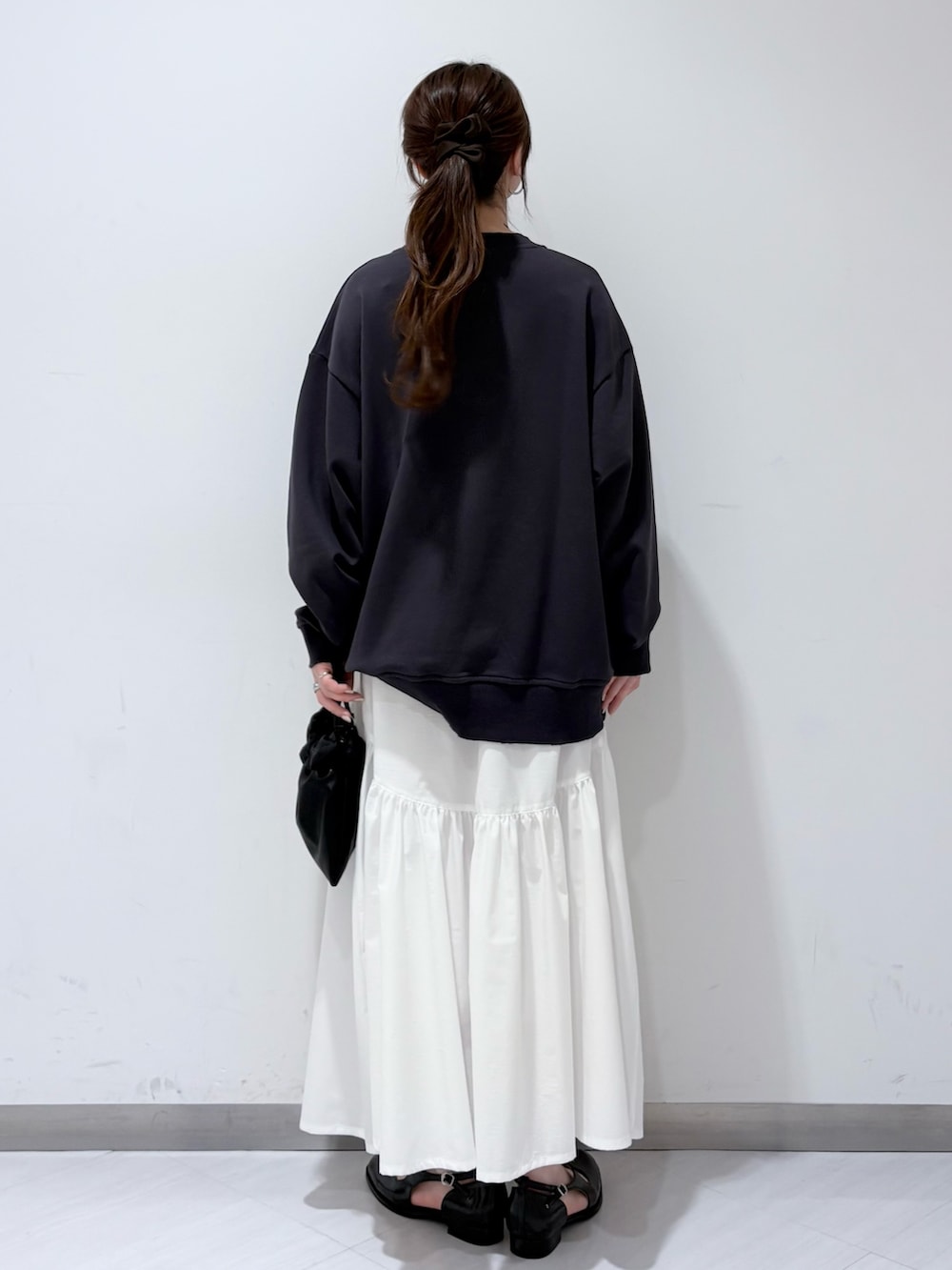 グレー系のスウェット、ブラック系のローファー、ホワイト系のスカートを着用したレディースの春コーディネートの3枚目の写真