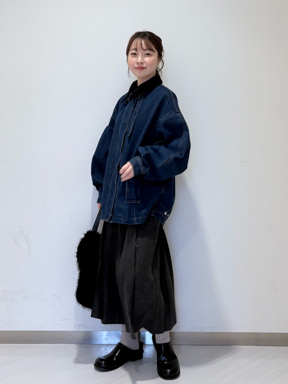 グレー系のニット/セーター、グレー系のスカート、ブラック系のその他シューズを着用したレディースの秋コーディネートの4枚目の写真